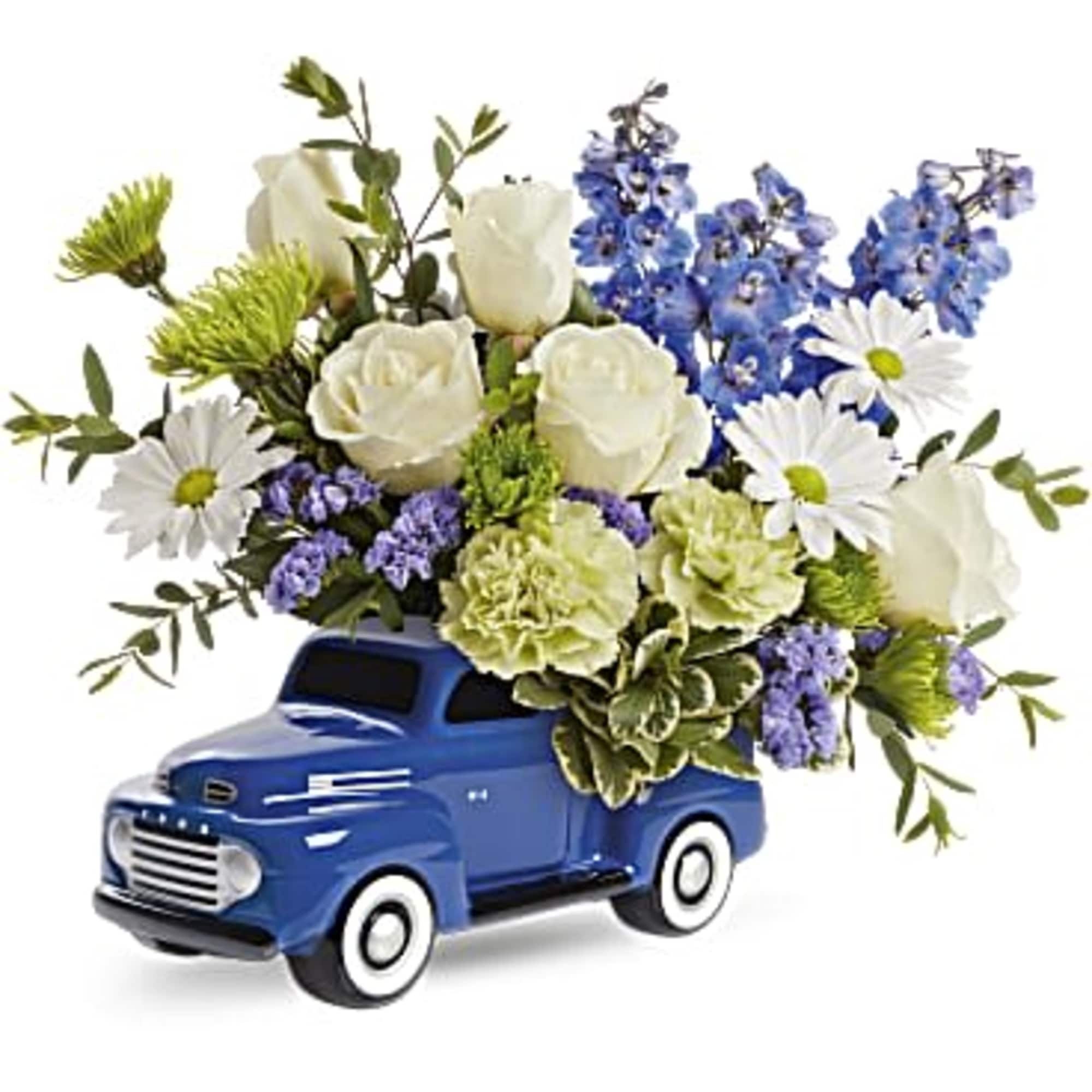 Blue toy truck filled with white and blue flowers