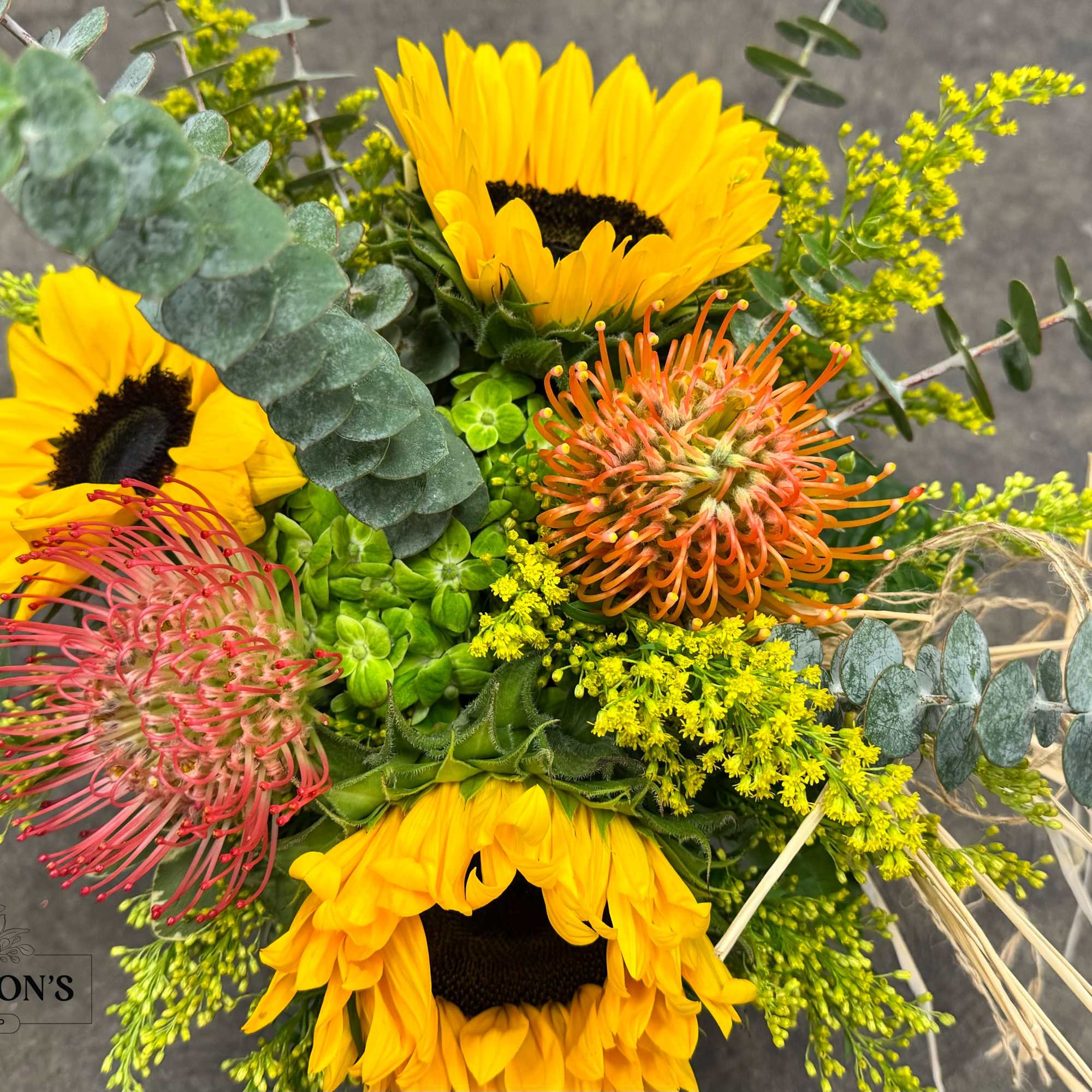 Bouquet with sunflowers, pink and orange pincushion blooms, and eucalyptus