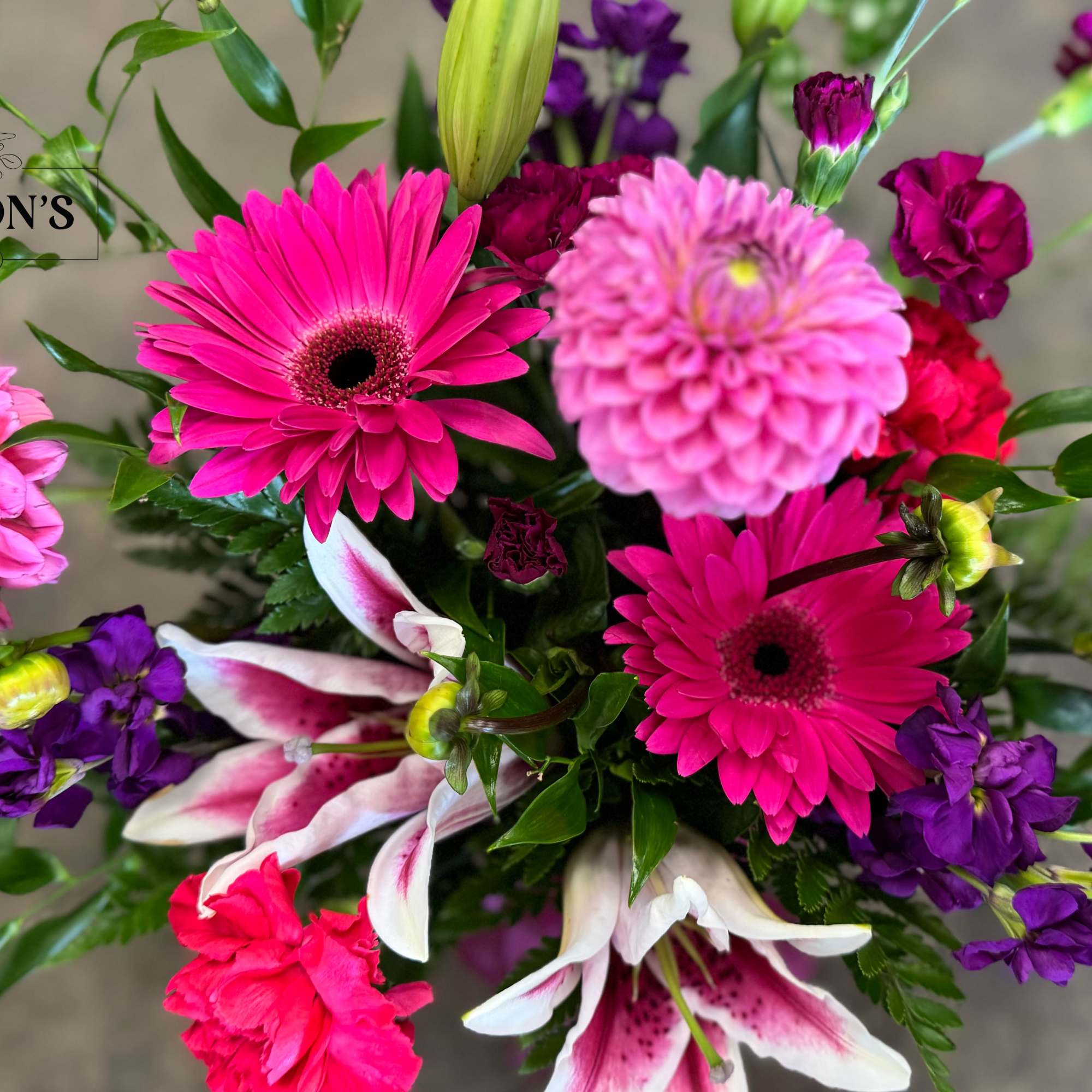 Bright pink and purple mixed bouquet with gerbera daisies, lilies, and carnations