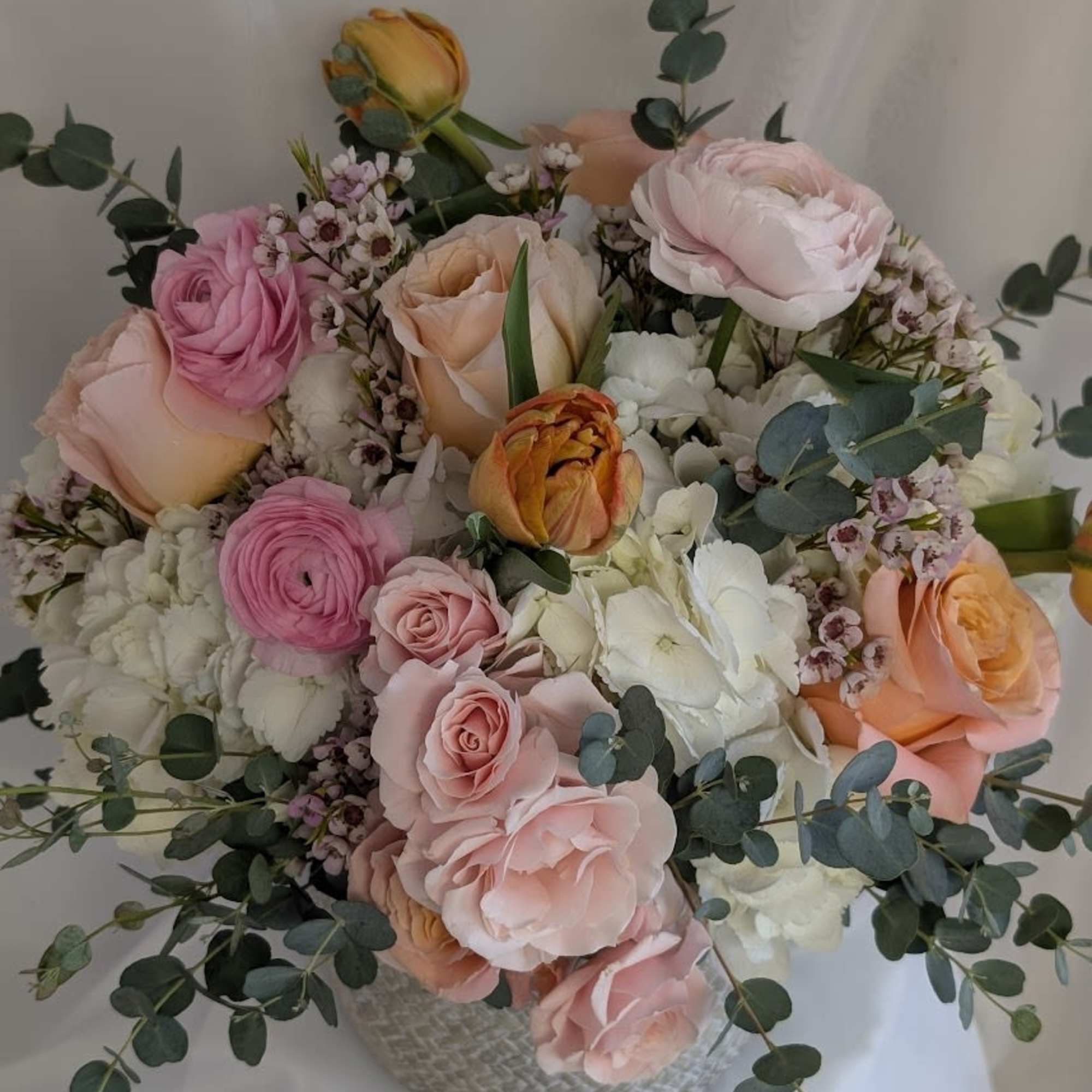 Peach roses, (seasonal blooms) White Hydrangea, White Roses, pink Ranunculus, double tulips