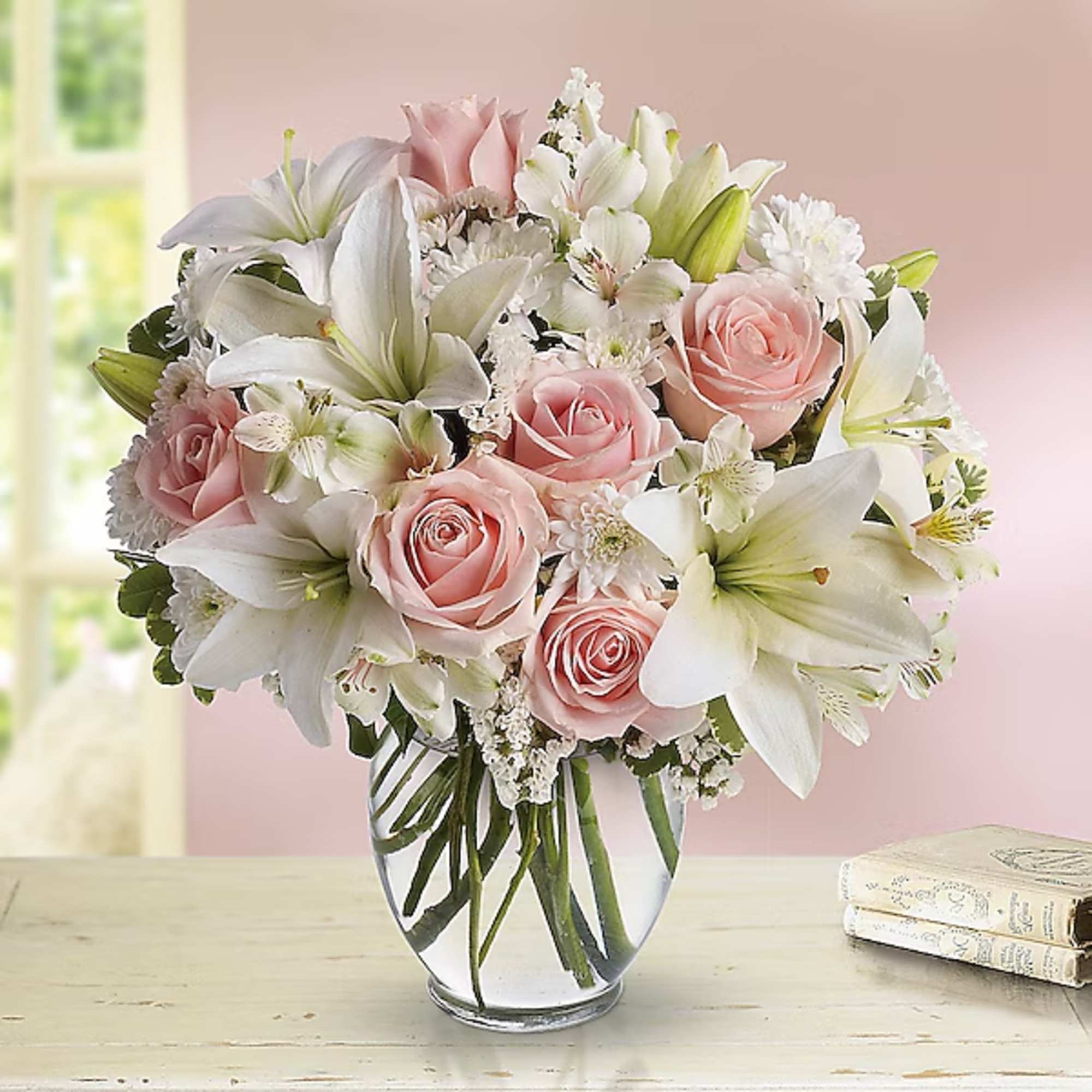 Pink roses and white lilies arranged in a clear glass vase, photo 2 of 2