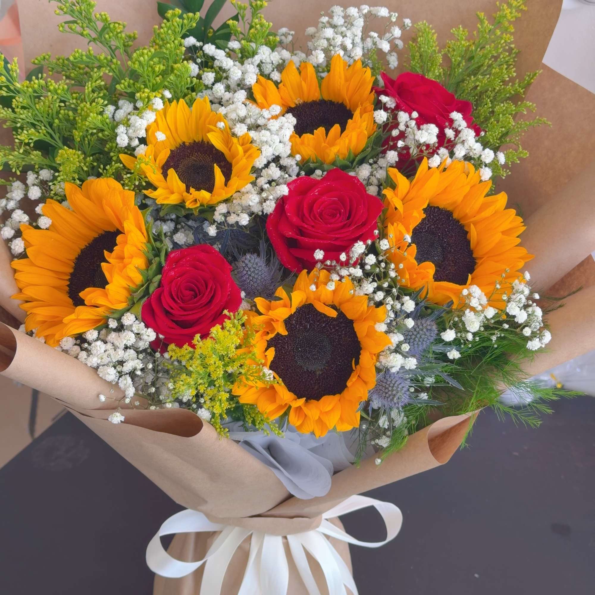 Bouquet of sunflowers and red roses wrapped in brown paper, photo 3 of 4