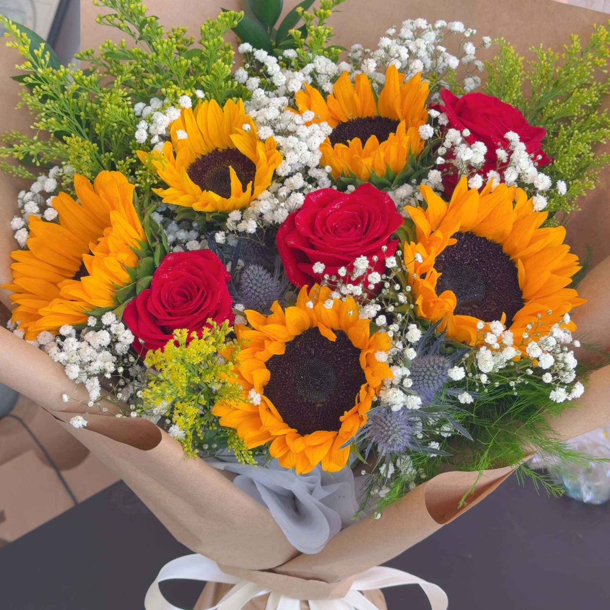 Bouquet of sunflowers and red roses wrapped in brown paper, photo 2 of 4