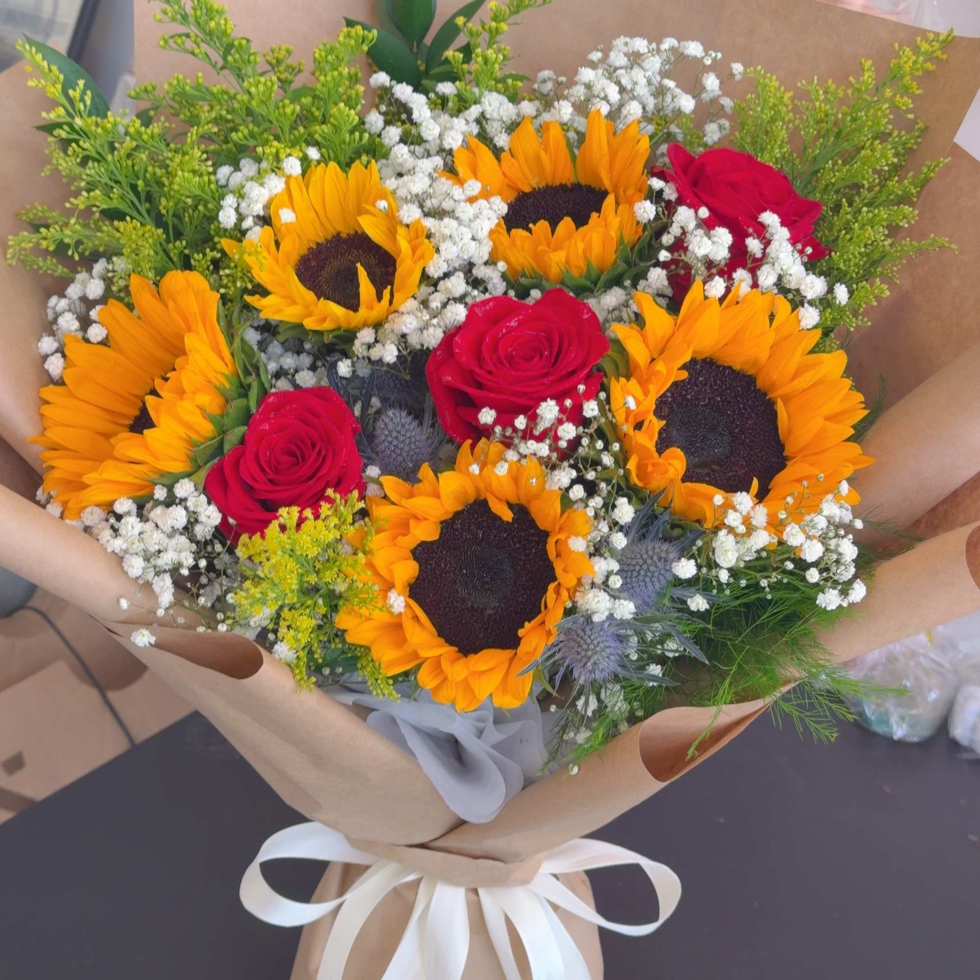 Bouquet of sunflowers and red roses wrapped in brown paper, photo 4 of 4