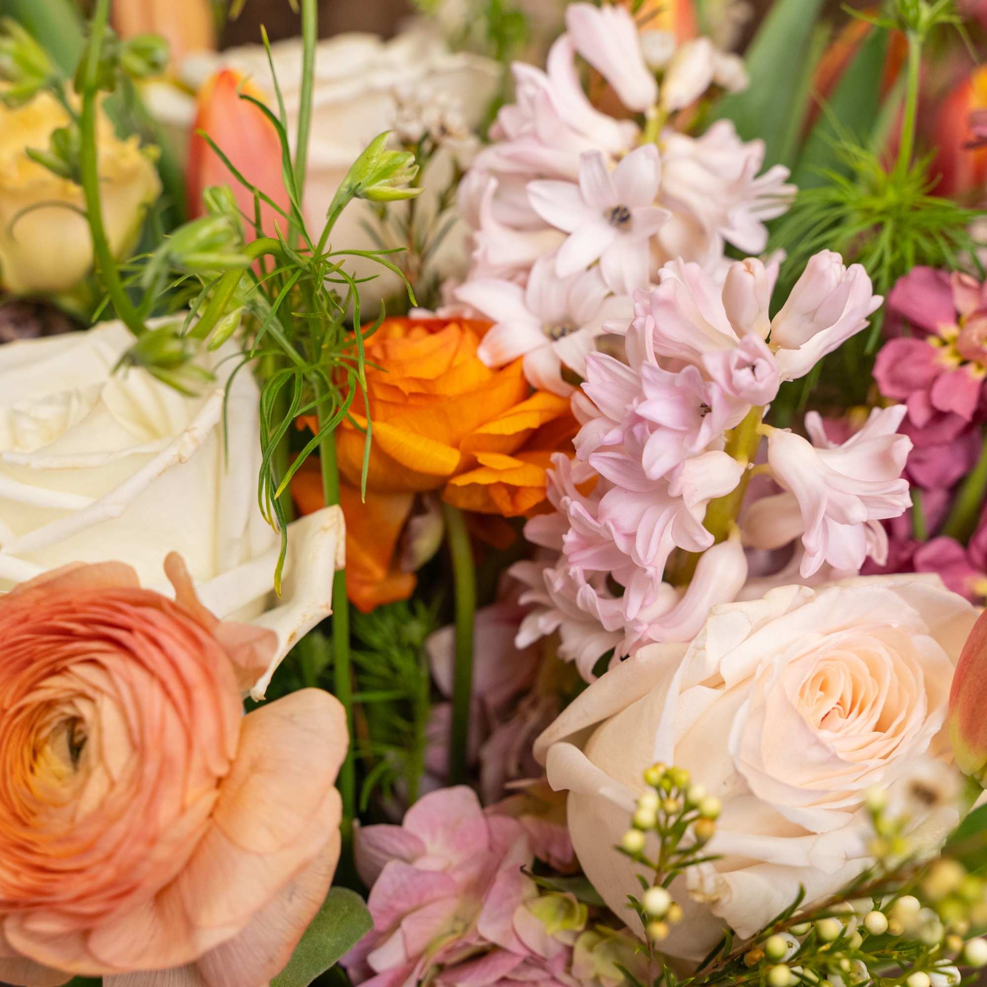 Close-up of a pastel mixed bouquet with roses, ranunculus, tulips, and hyacinths