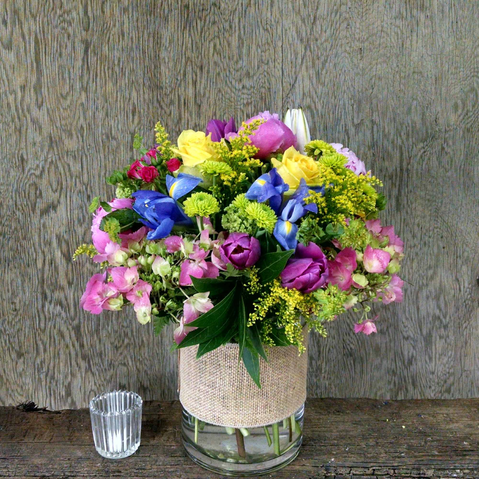 Mixed bouquet in a glass vase with burlap wrap