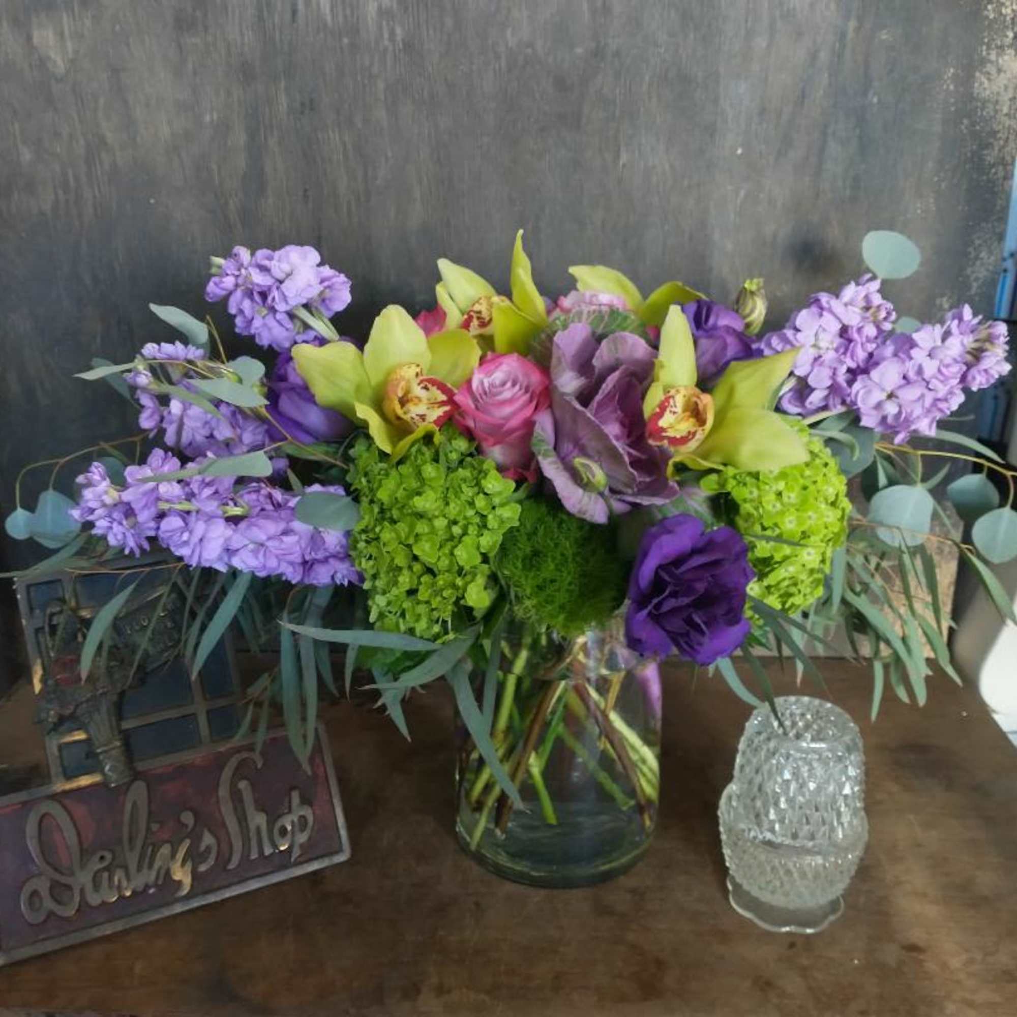 Purple and green mixed bouquet in a glass vase