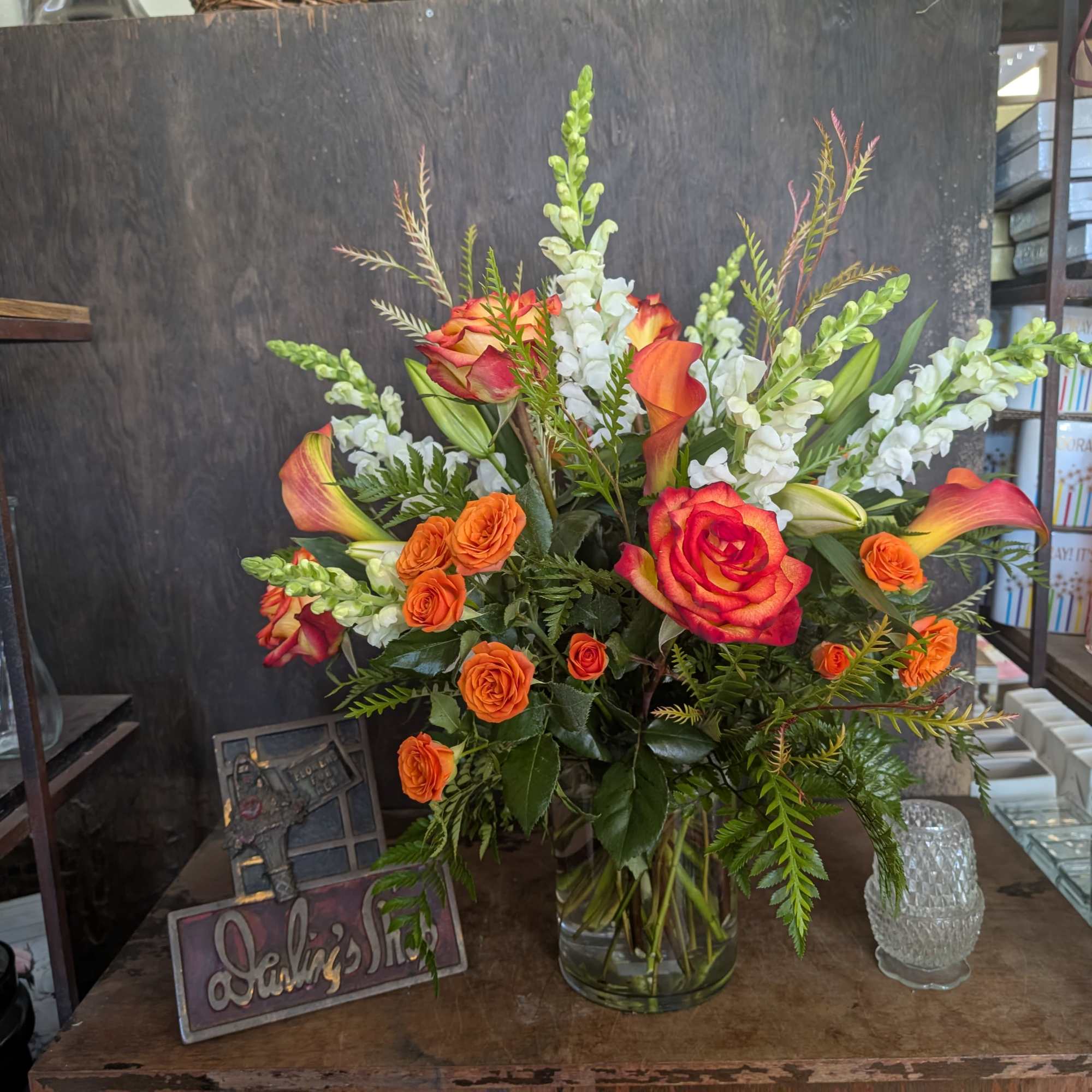 Orange roses and white snapdragons in a glass vase
