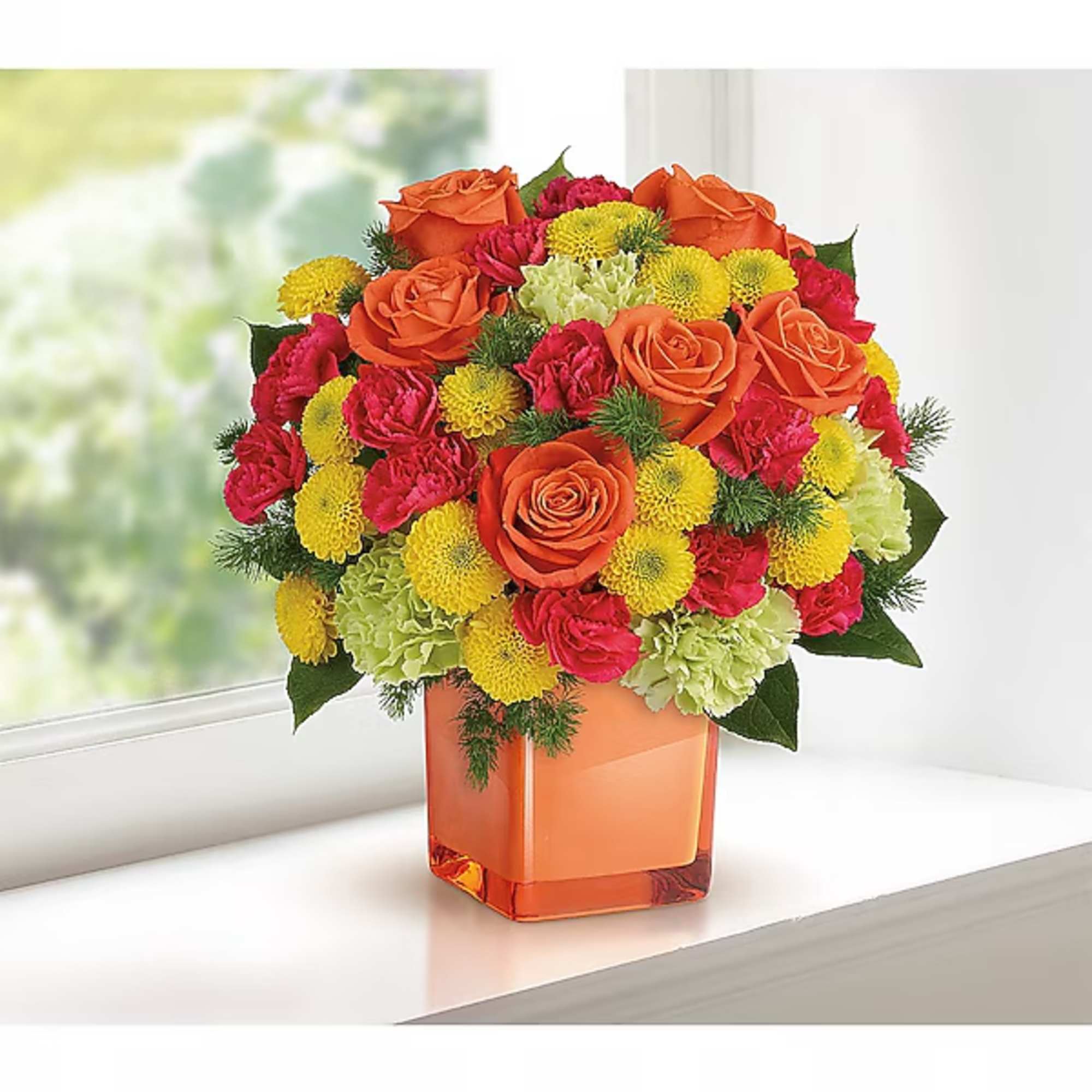 Orange roses, pink carnations, and yellow mums in an orange glass vase