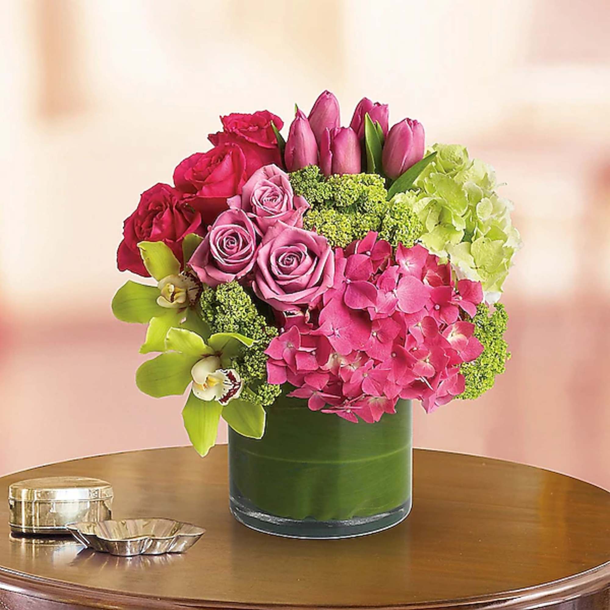 Pink and red roses with tulips and hydrangeas in a green vase
