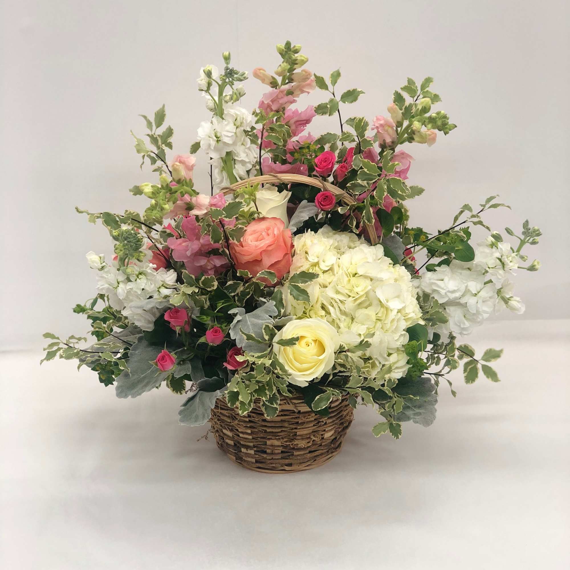 Mixed pink and white flowers in a wicker basket