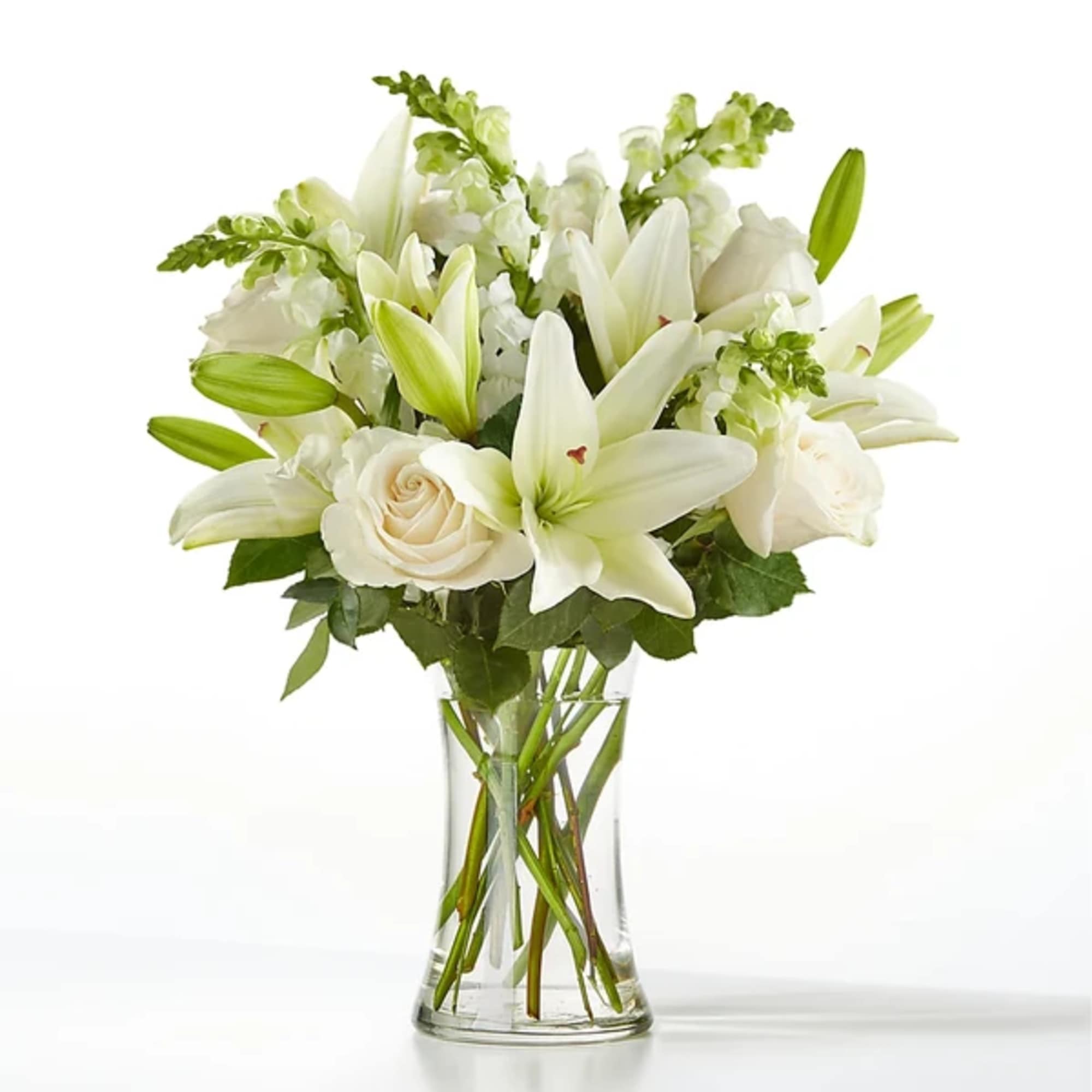 White lilies and roses in a clear glass vase