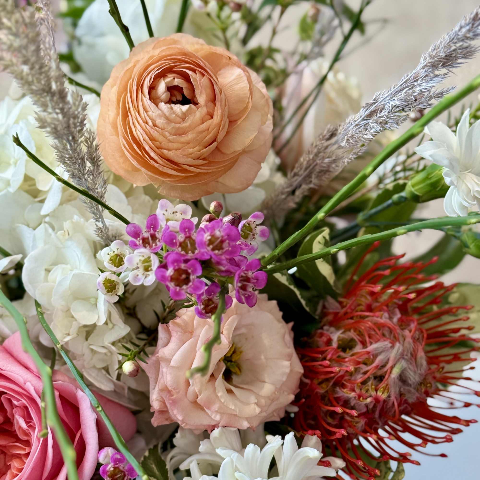 Mixed bouquet with peach, pink, white, and red flowers