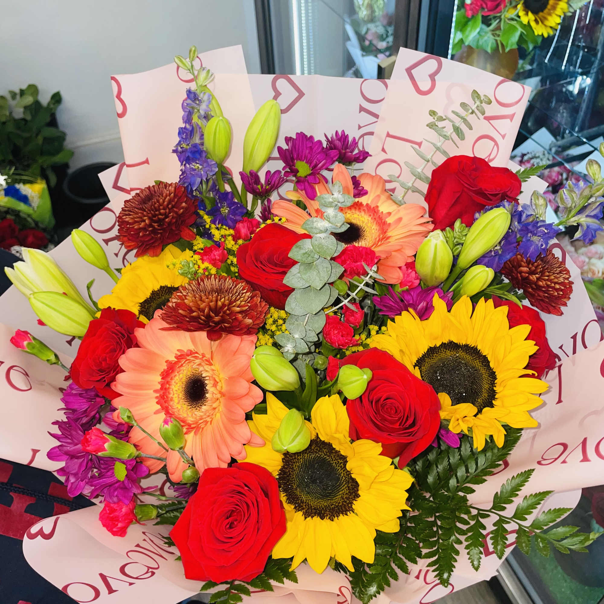 Mixed bouquet of red roses, sunflowers, and pink gerbera daisies