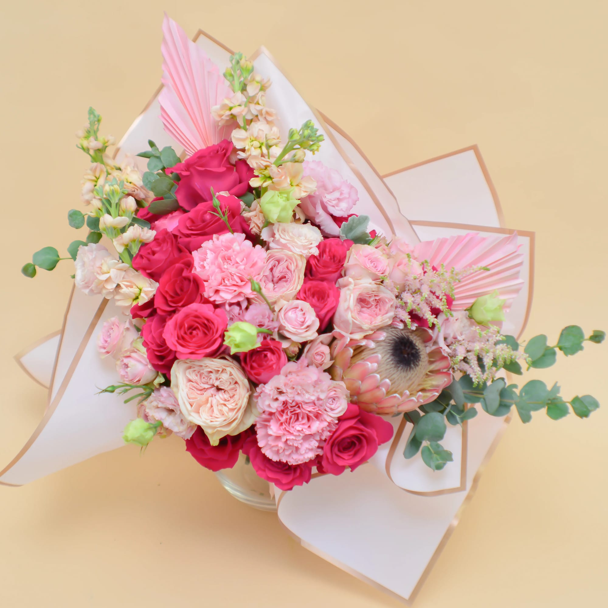 Pink and red rose bouquet with mixed blooms in white wrapping