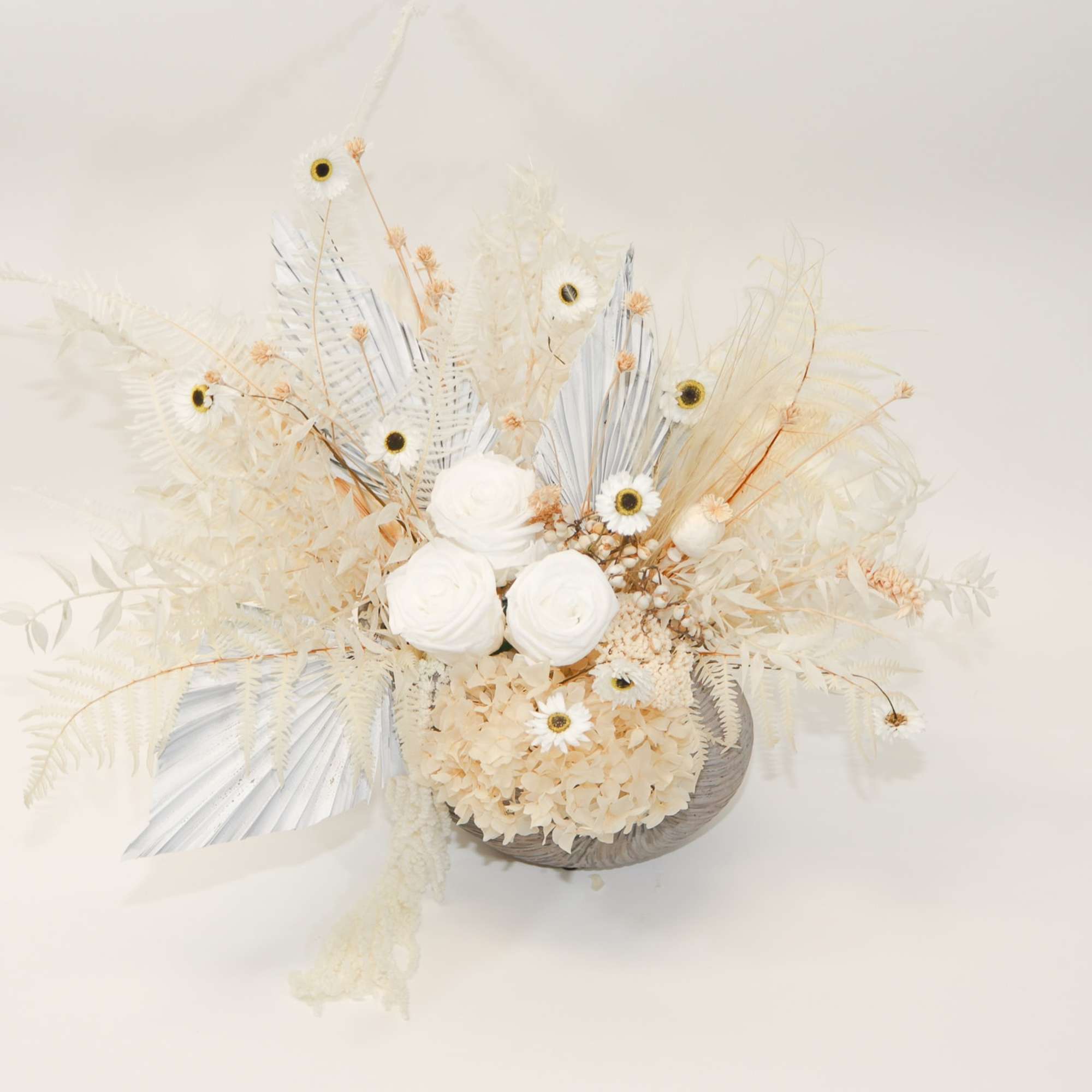 Cream-colored floral arrangement with white blooms and dried accents