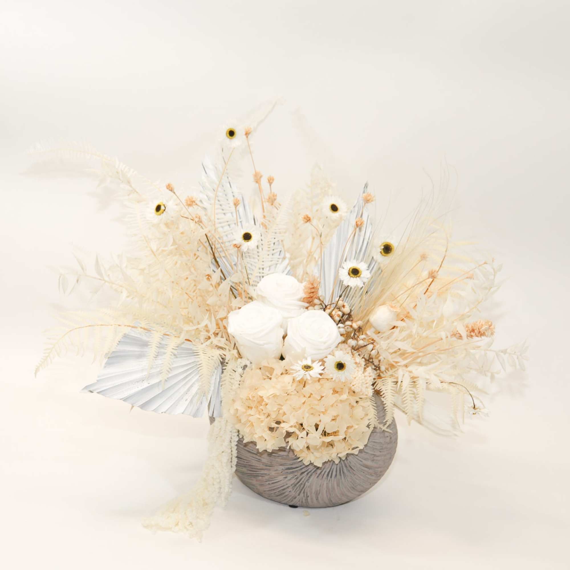 Cream-colored floral arrangement in a textured gray vase