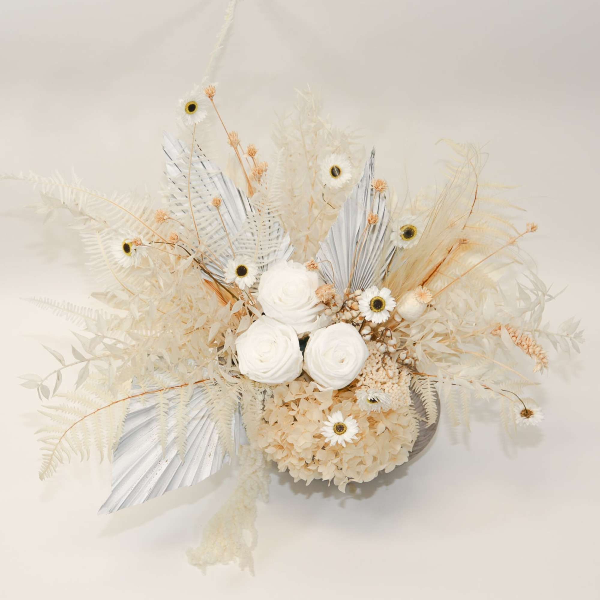 Cream floral arrangement with white roses and small daisy-like blooms