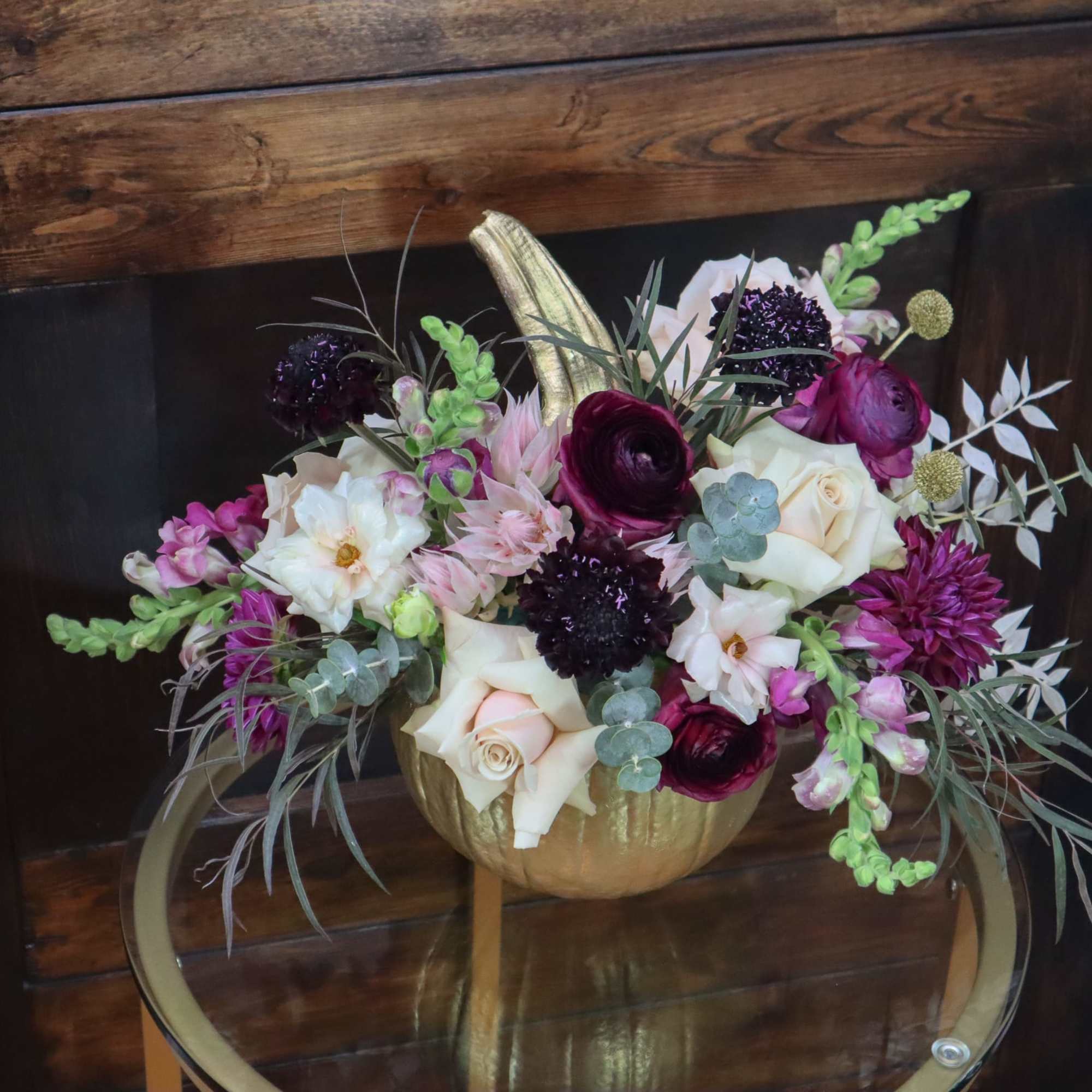 Mixed bouquet in a gold pumpkin vase with white, pink, and purple blooms
