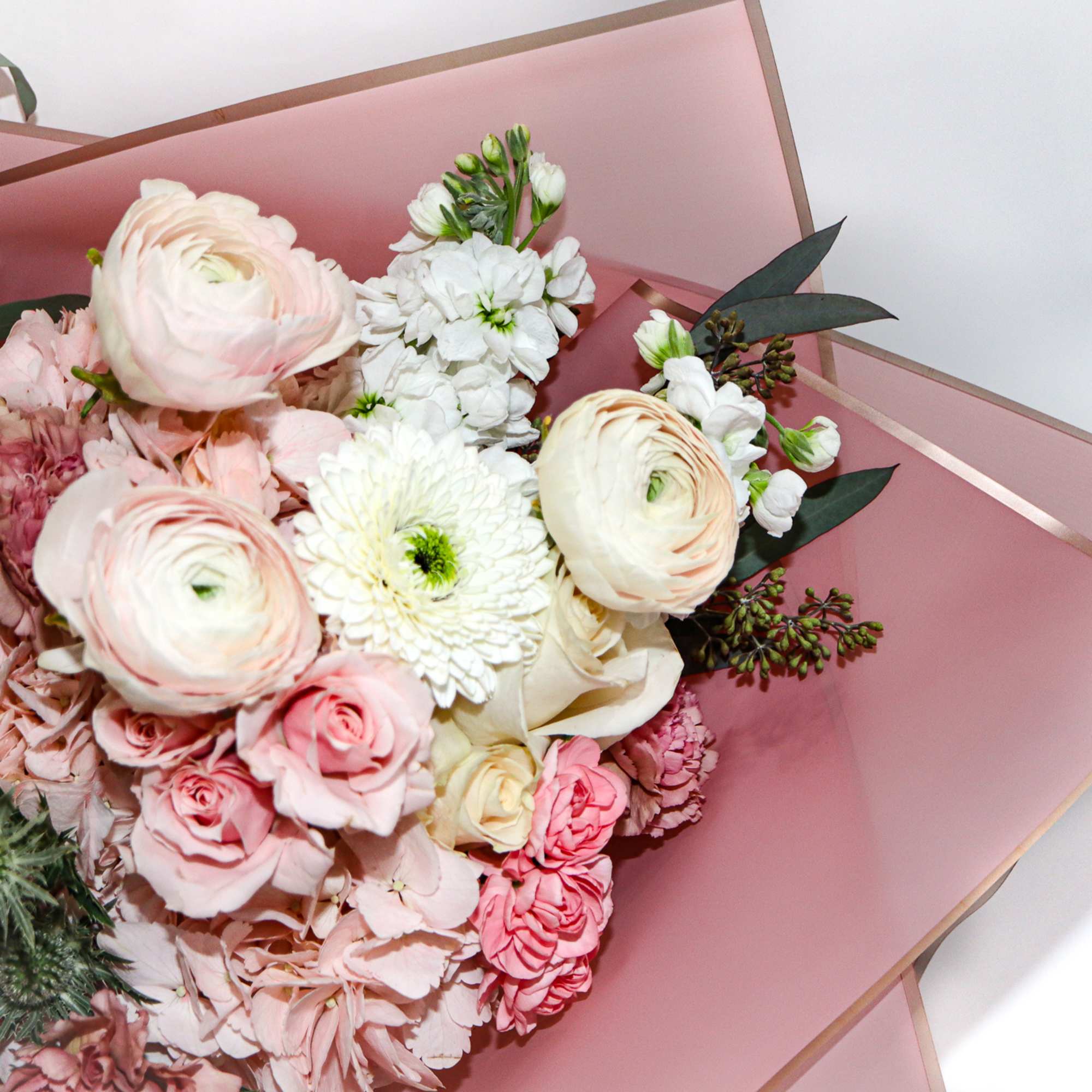Bouquet of pale pink and white flowers wrapped in pink paper