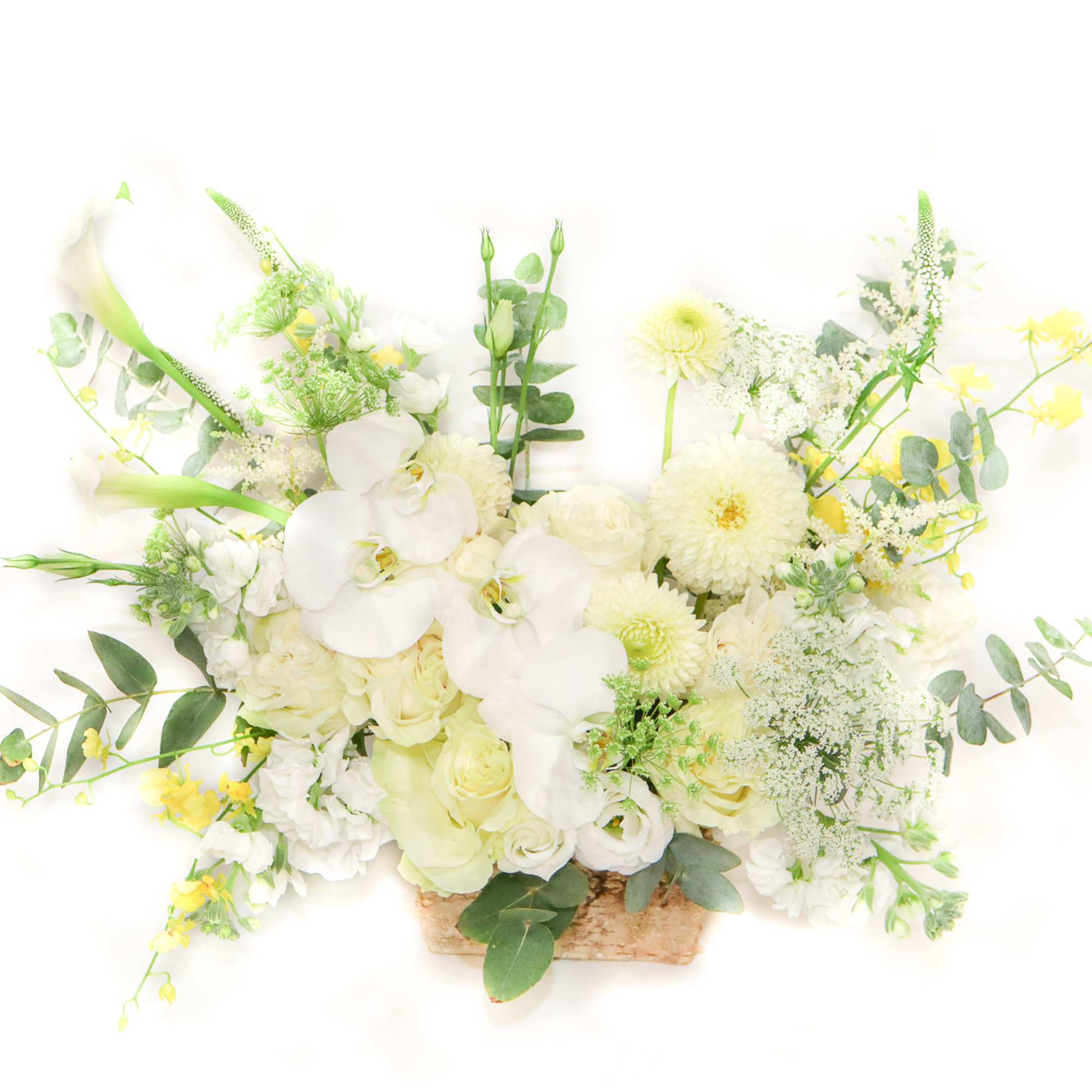 White floral arrangement with orchids and calla lilies in a woven basket