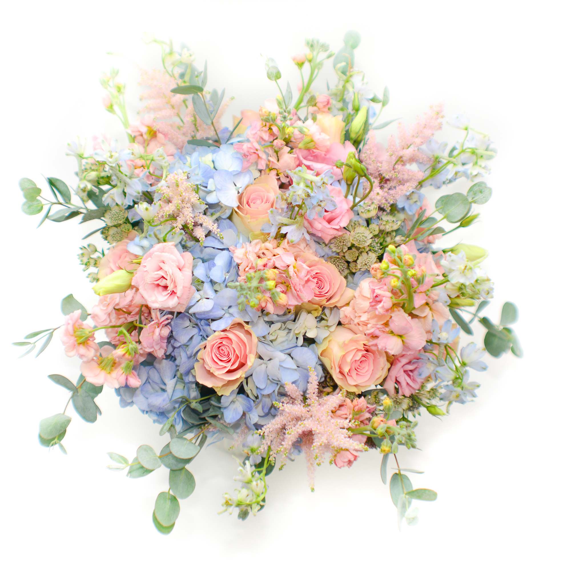 Pastel bouquet of pink roses, blue hydrangeas, and airy filler flowers