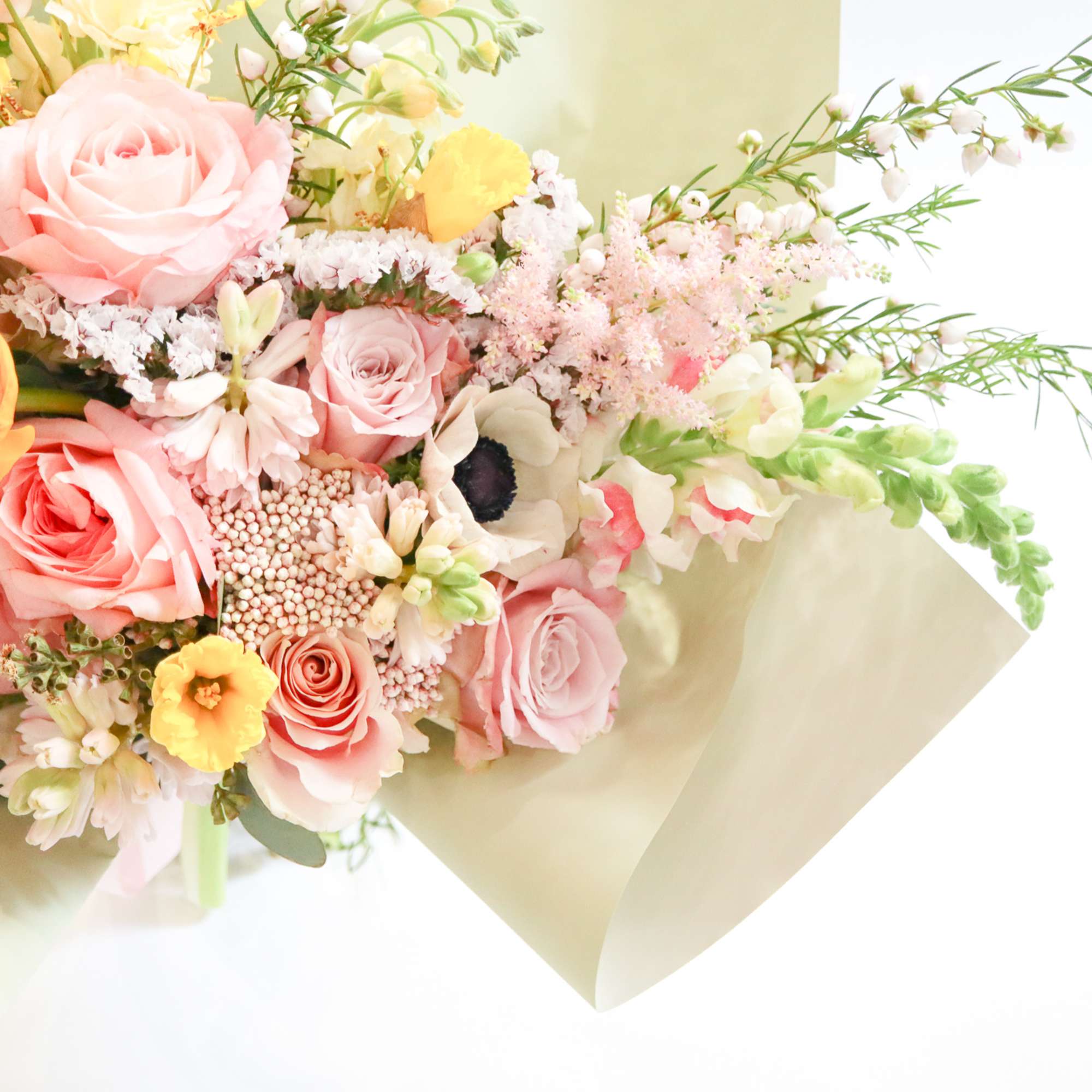 Pastel bouquet of roses, ranunculus, and small filler flowers