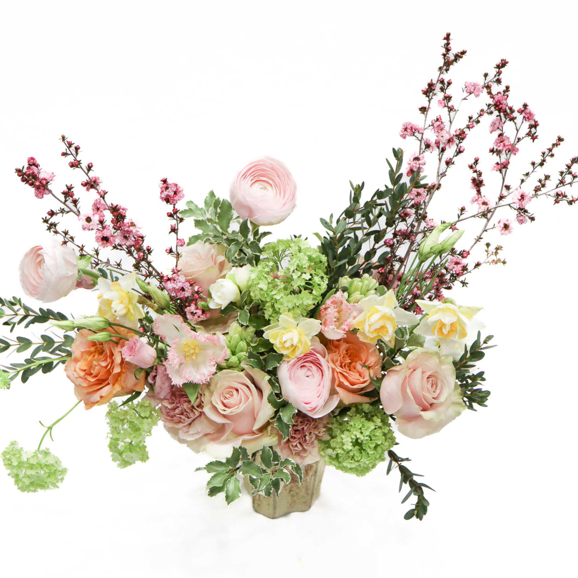 Pastel floral arrangement in a small vase with pink and peach blooms