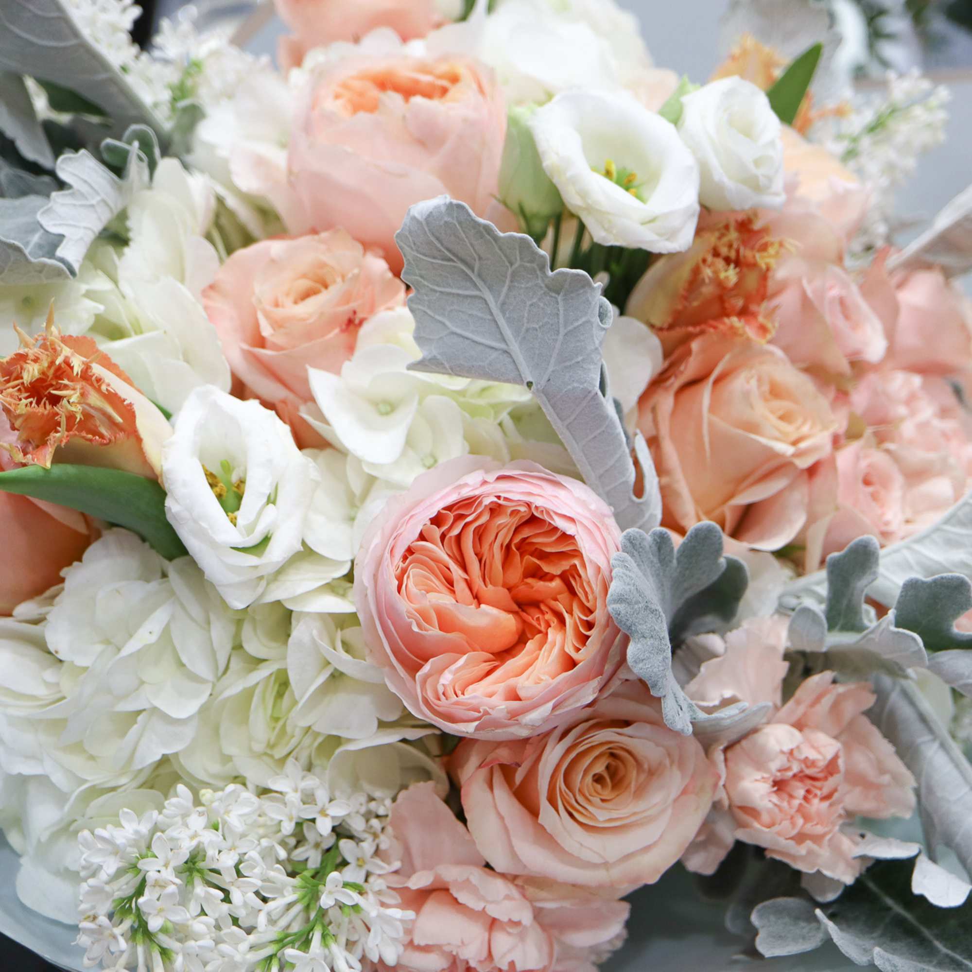 Bouquet of peach and white flowers with silvery foliage