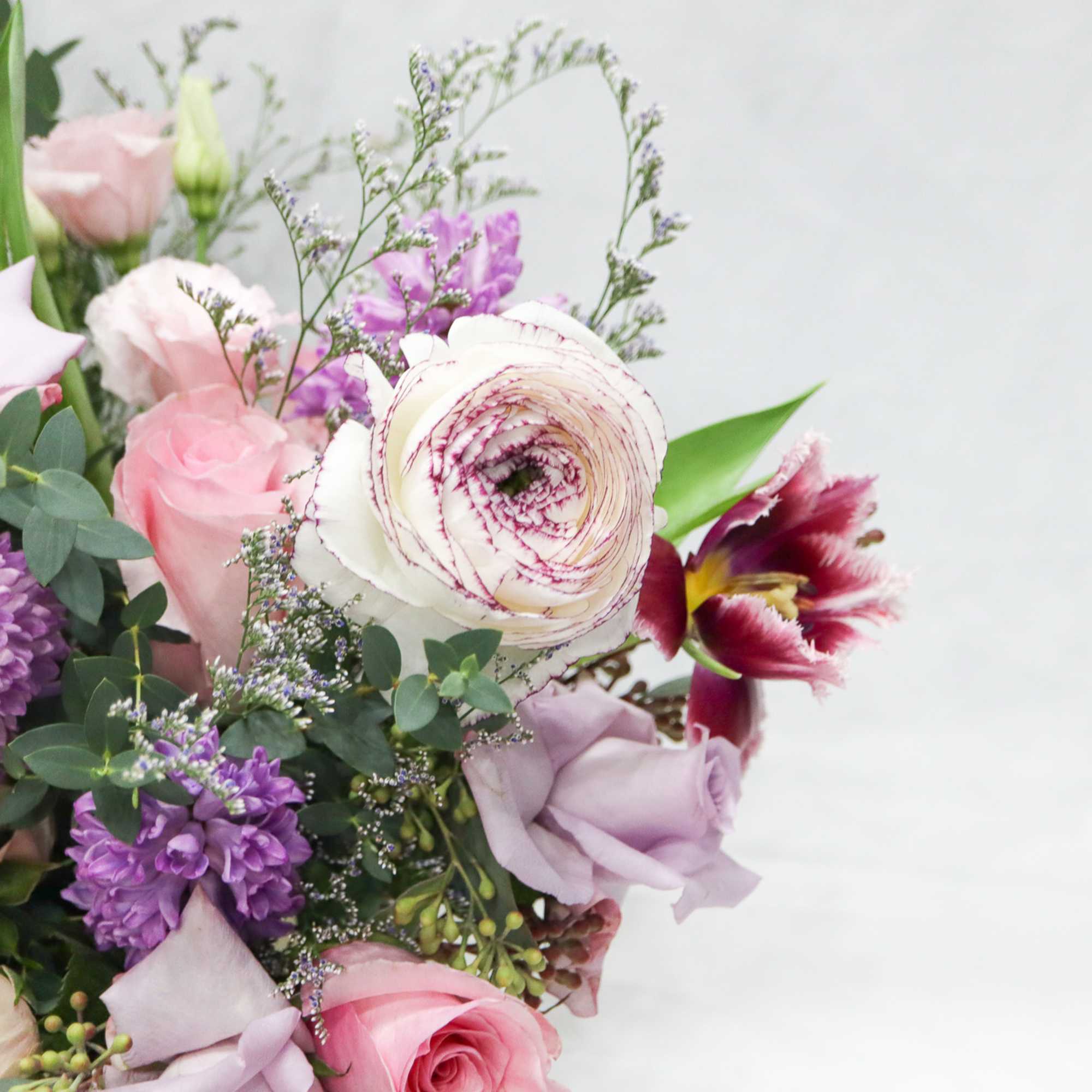 Bouquet of pink, lavender, and white flowers with greenery
