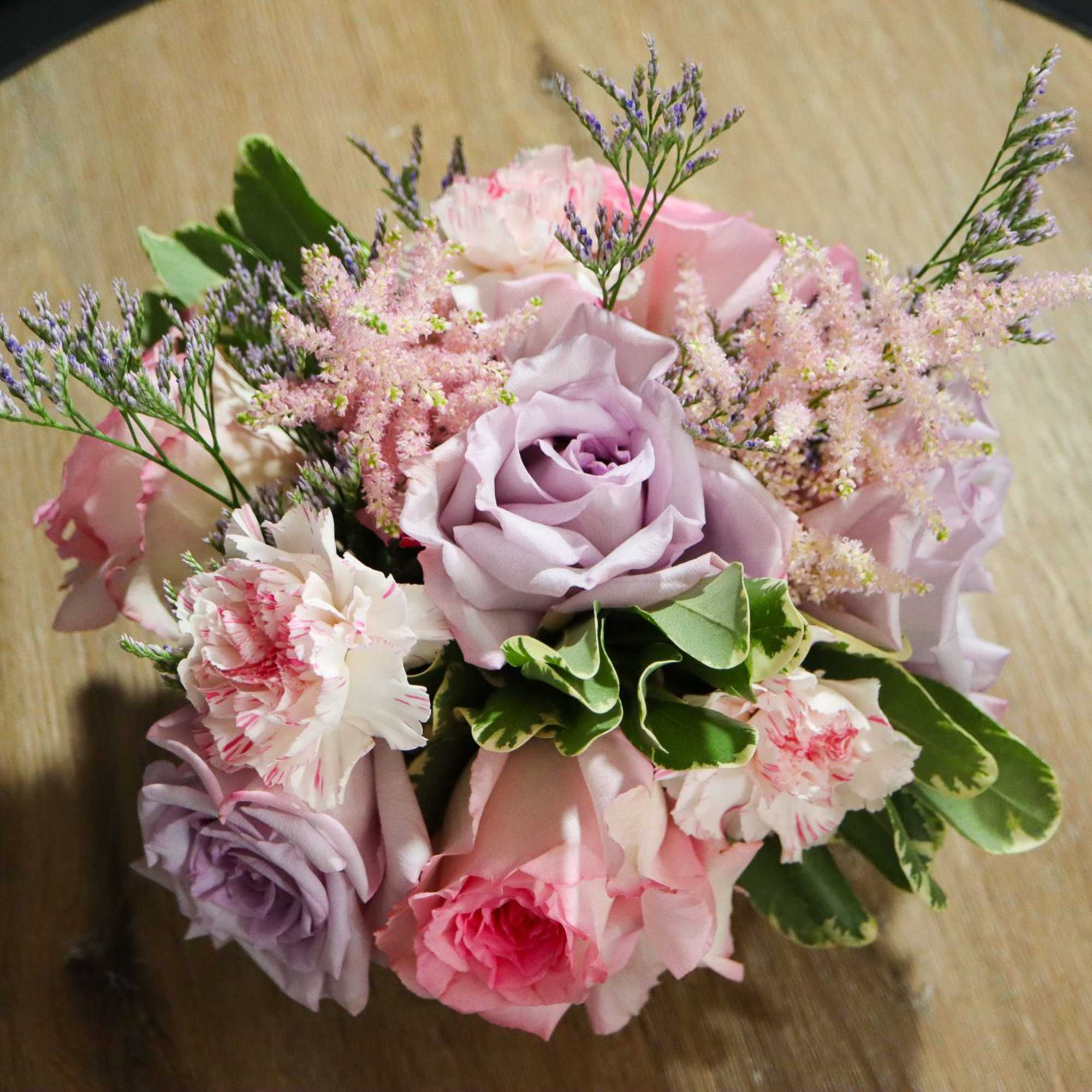 Bouquet of pink and lavender roses with small filler flowers