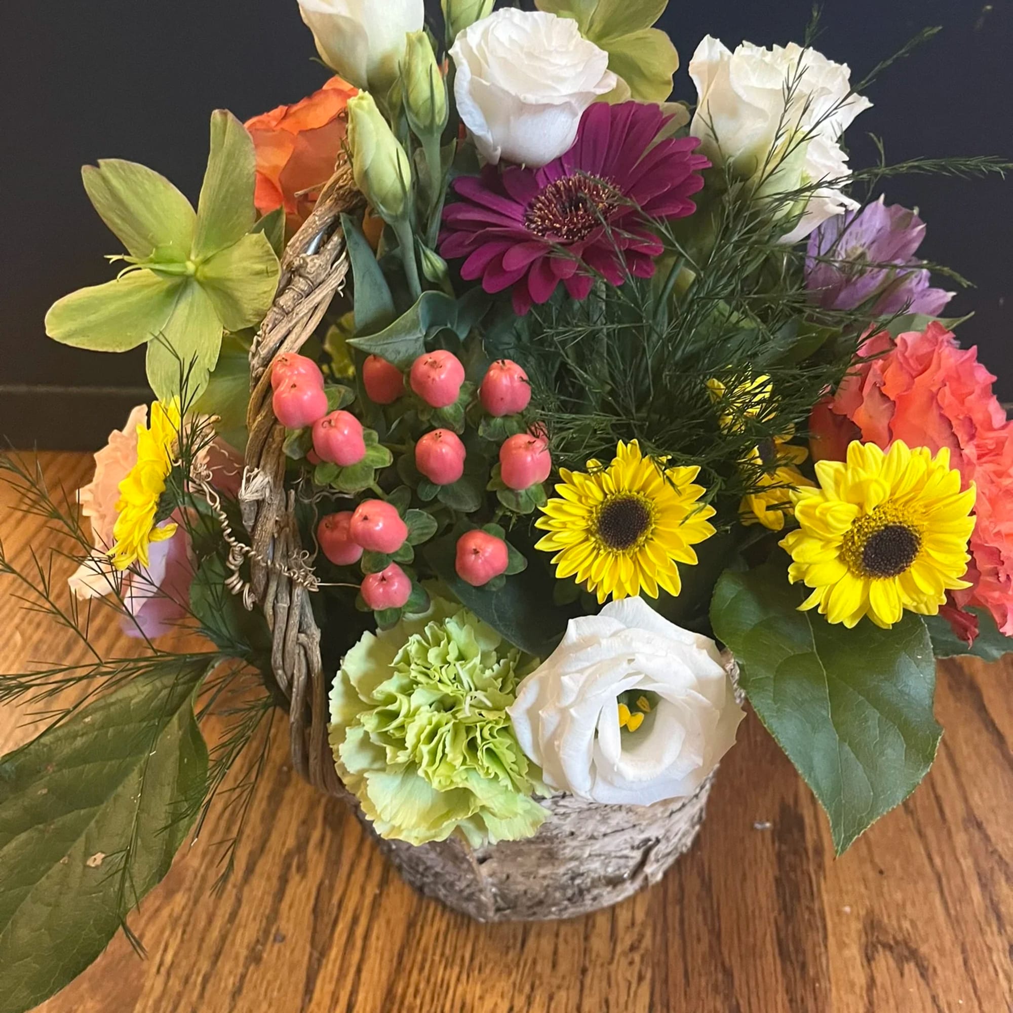 Colorful mixed flower arrangement in a birch basket with bright blooms