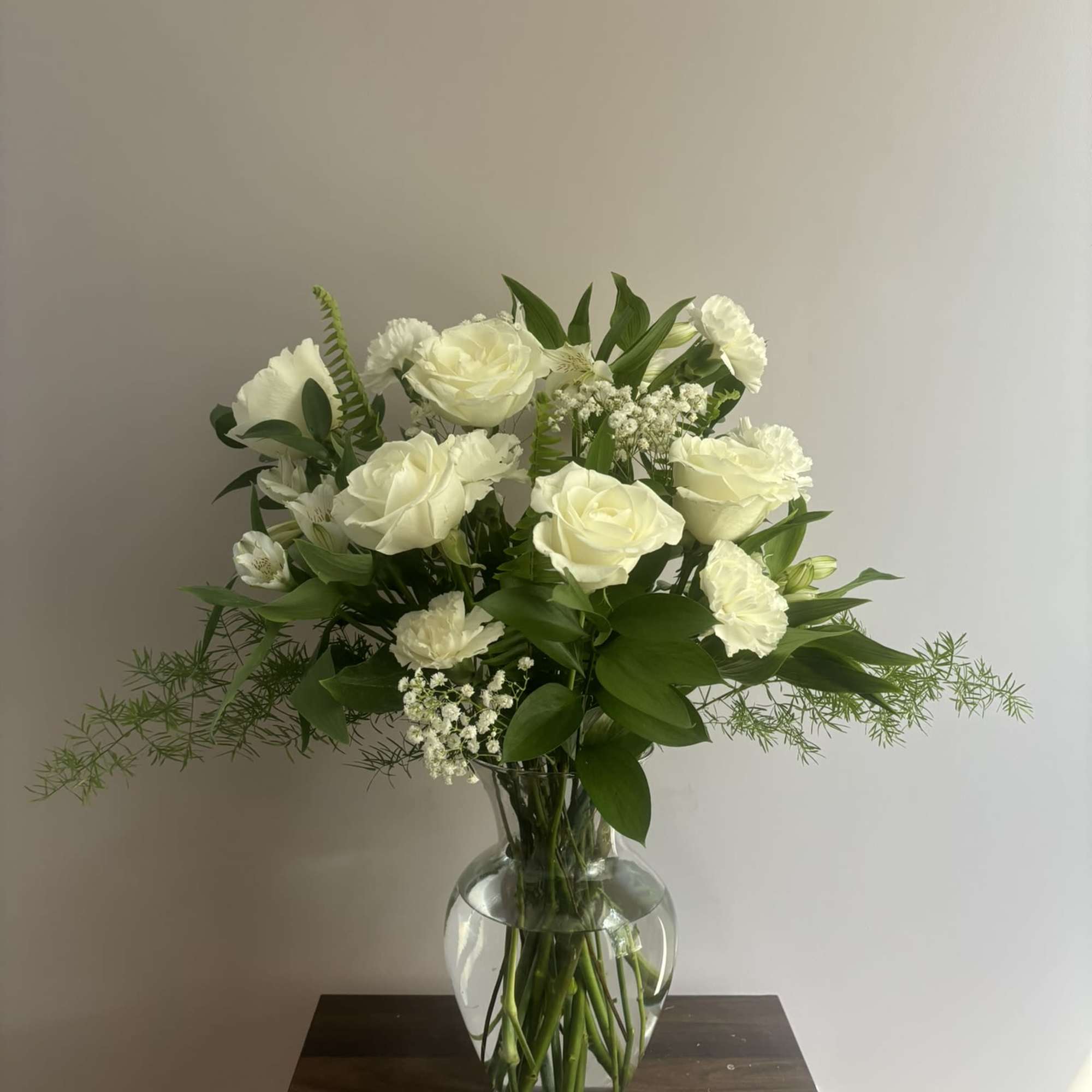 White roses and carnations arranged in a clear glass vase, photo 2 of 3