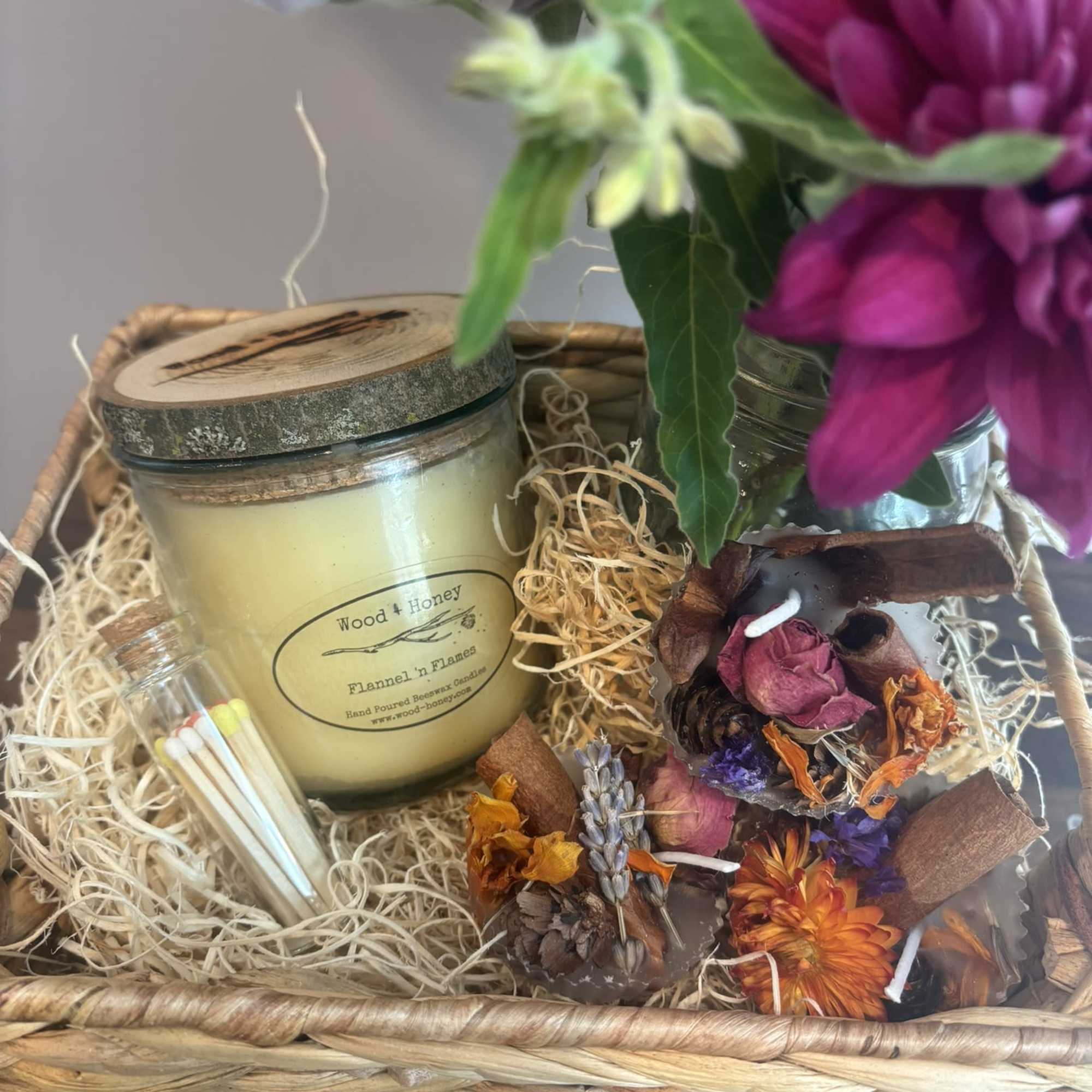 Gift basket with a candle, matches, dried flowers, and a small bouquet