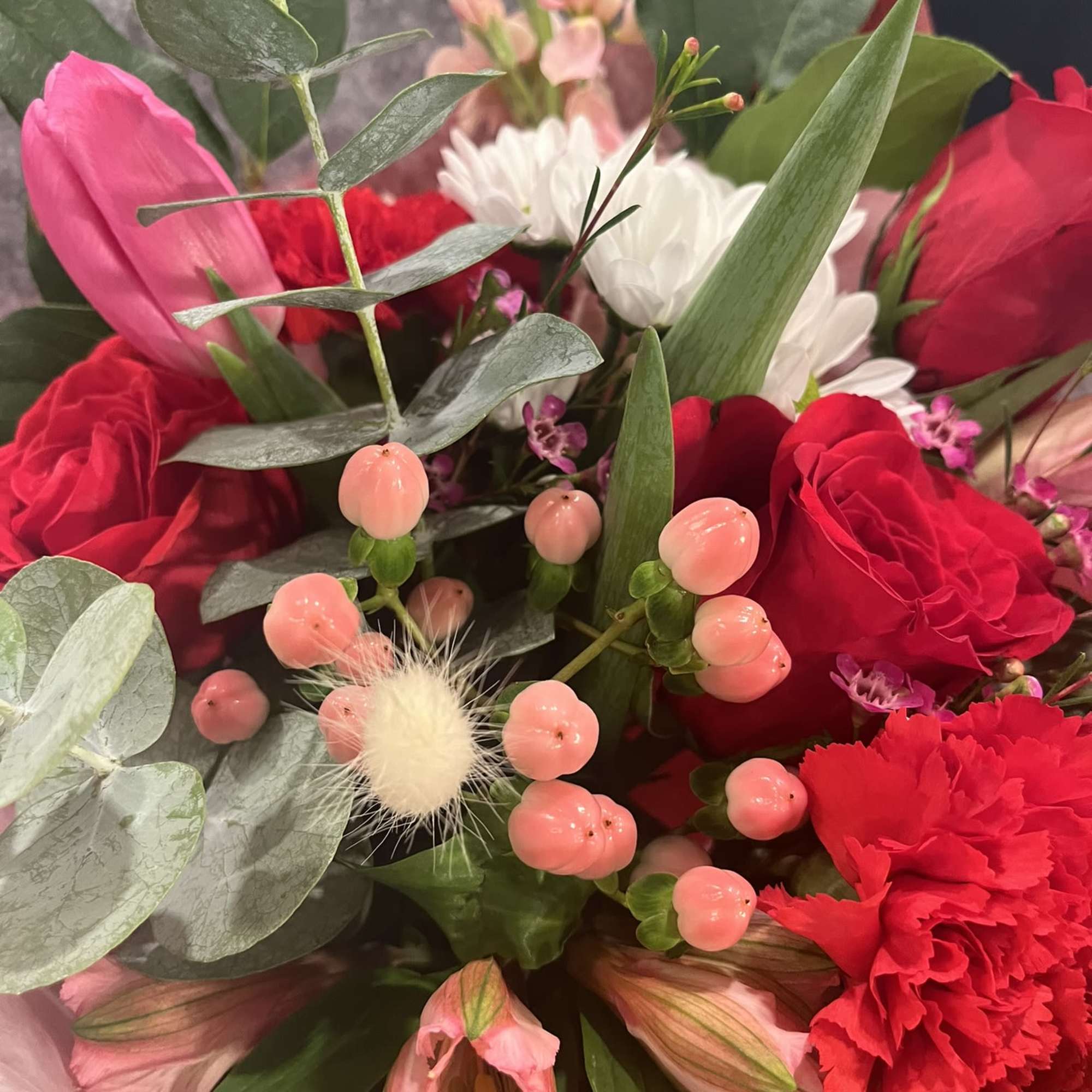 Bouquet of red and pink flowers with white daisies and eucalyptus