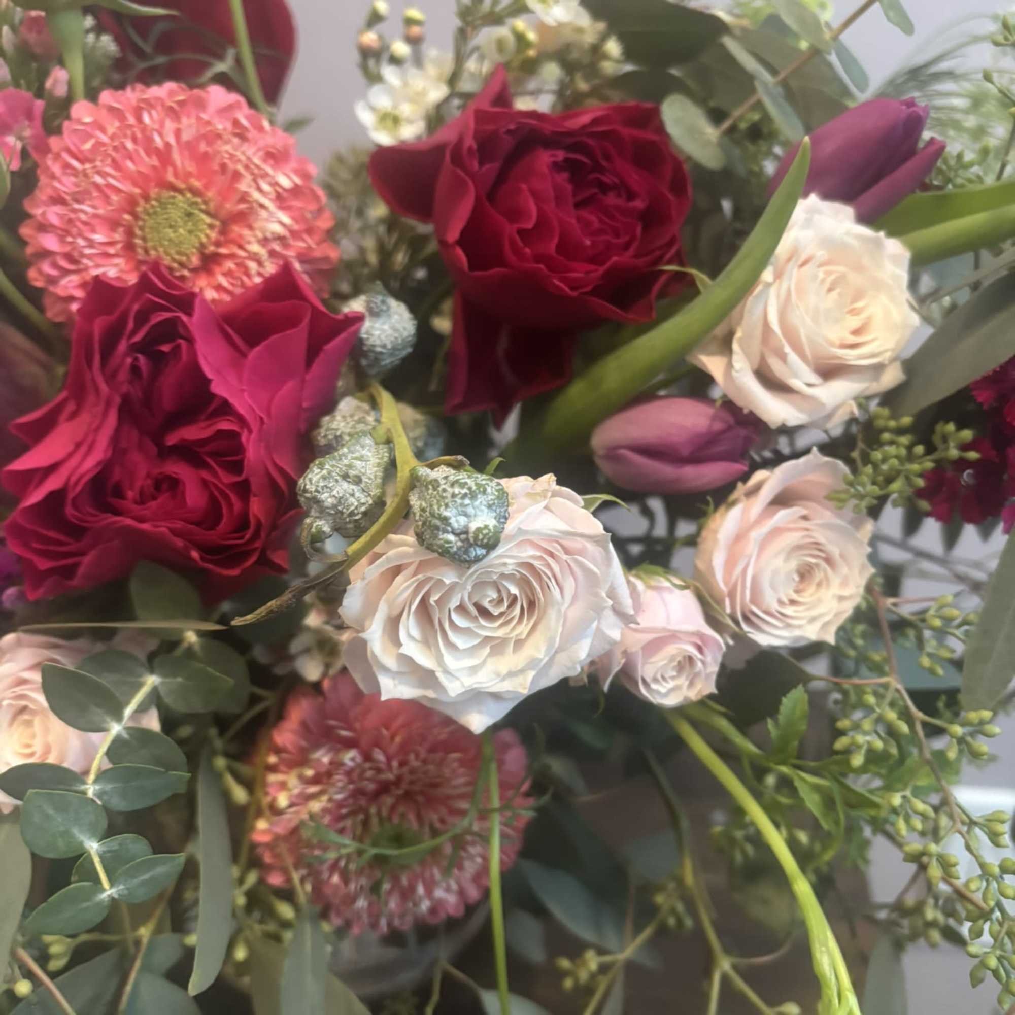 Bouquet of red and blush roses with pink blooms and greenery