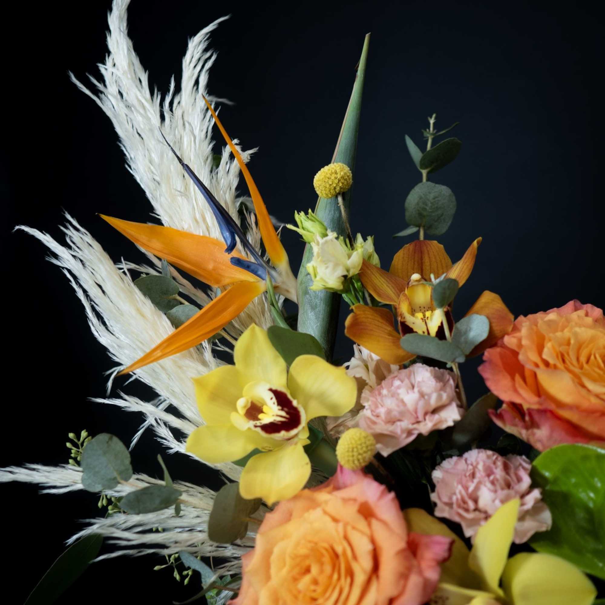 Bouquet with orange roses, yellow orchids, and white pampas grass