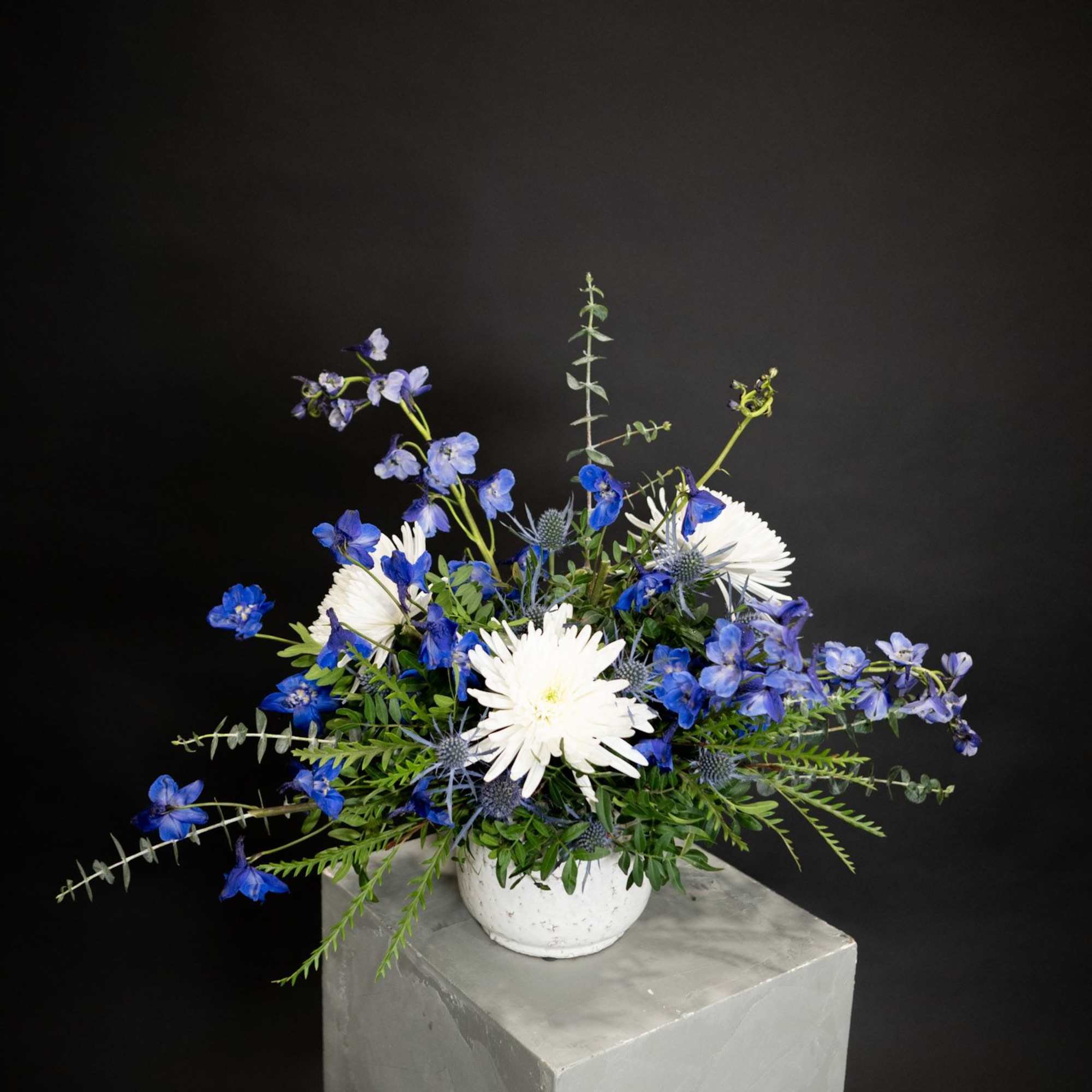 Blue and white flower arrangement in a white vase