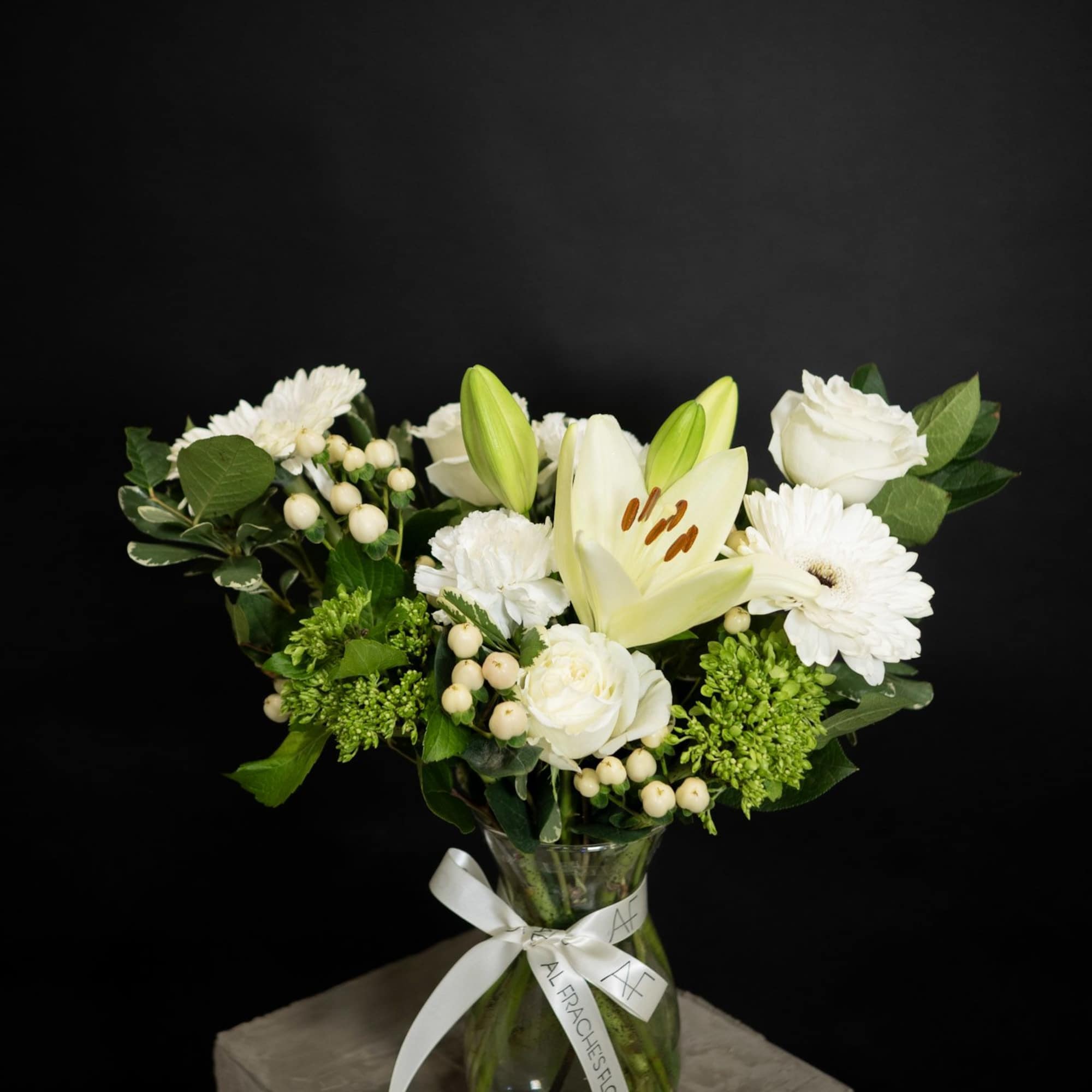 White lily and rose bouquet in a glass vase