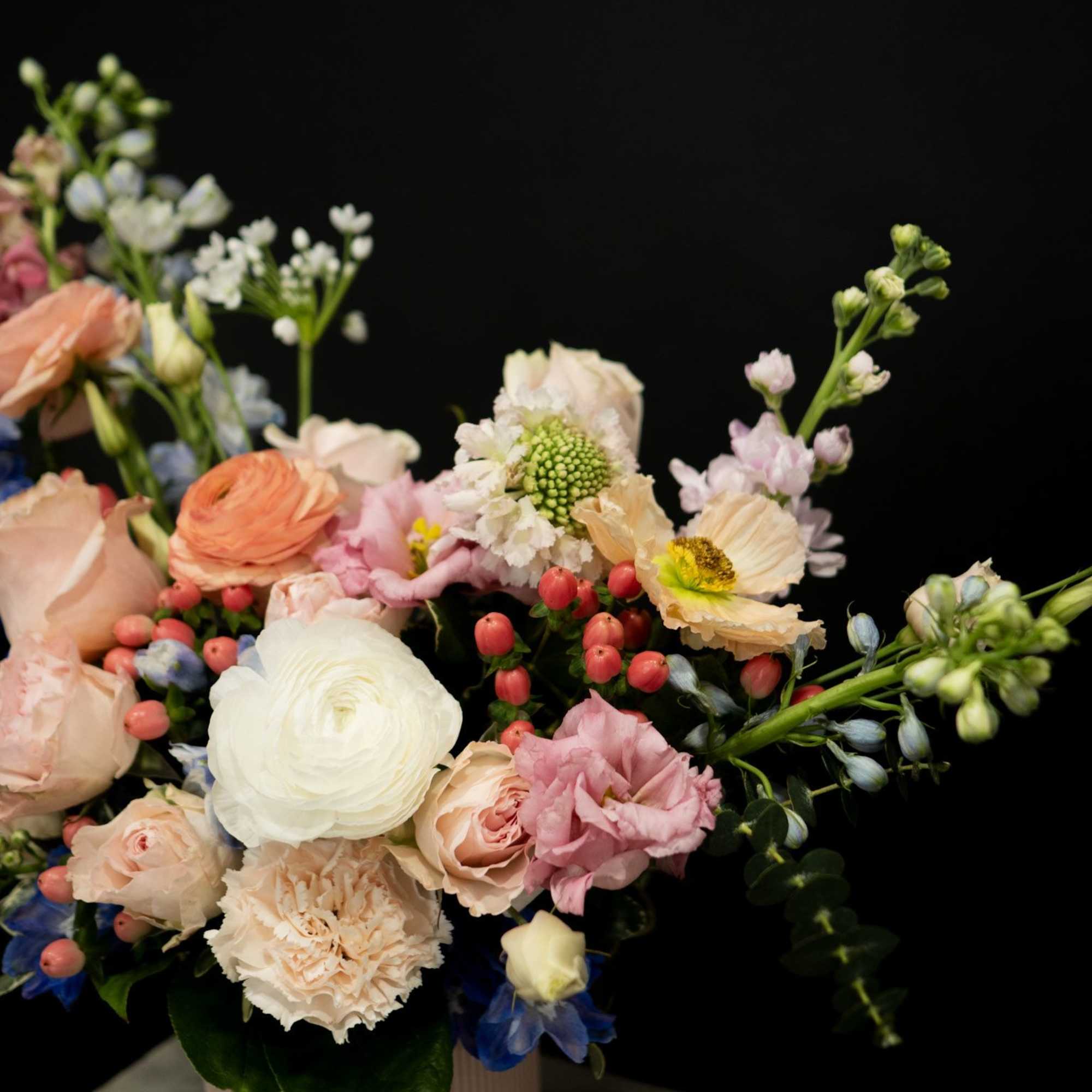 Pastel mixed flower arrangement in a pink vase
