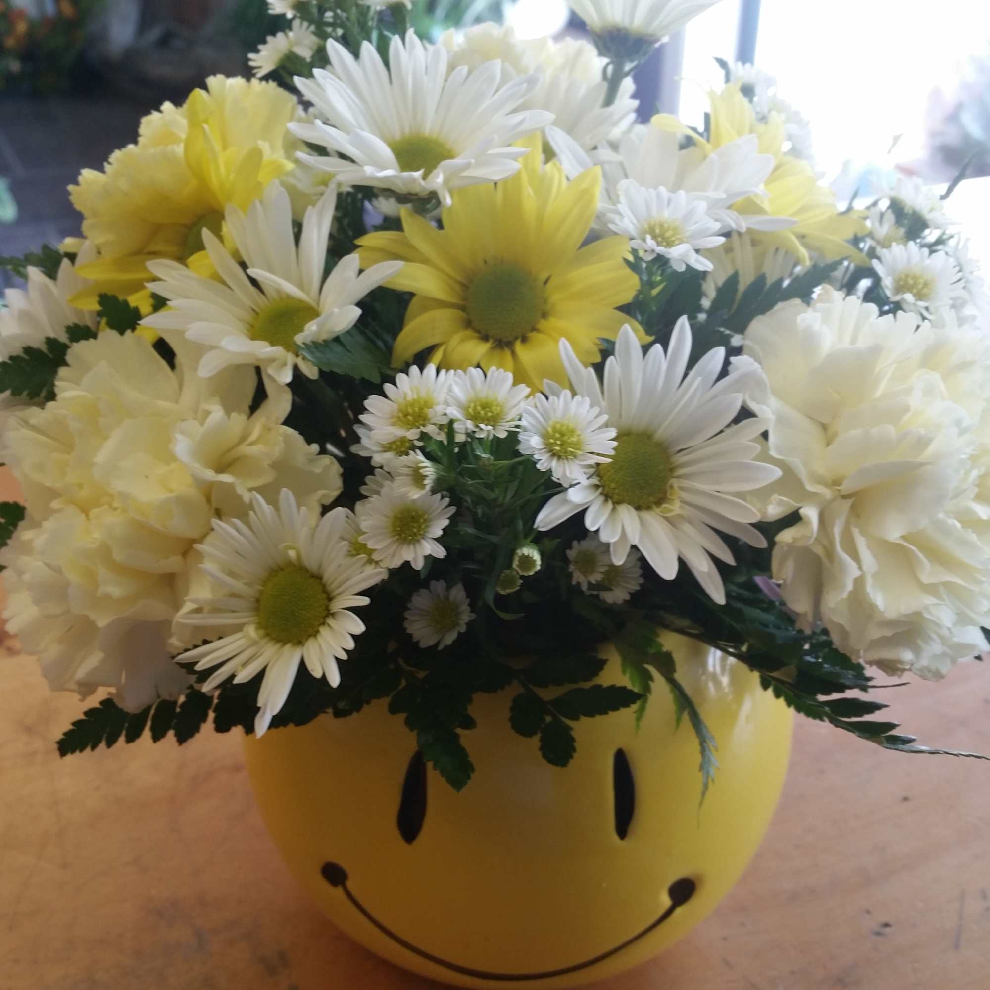Yellow and white daisy bouquet in a smiley-face vase, photo 2 of 2