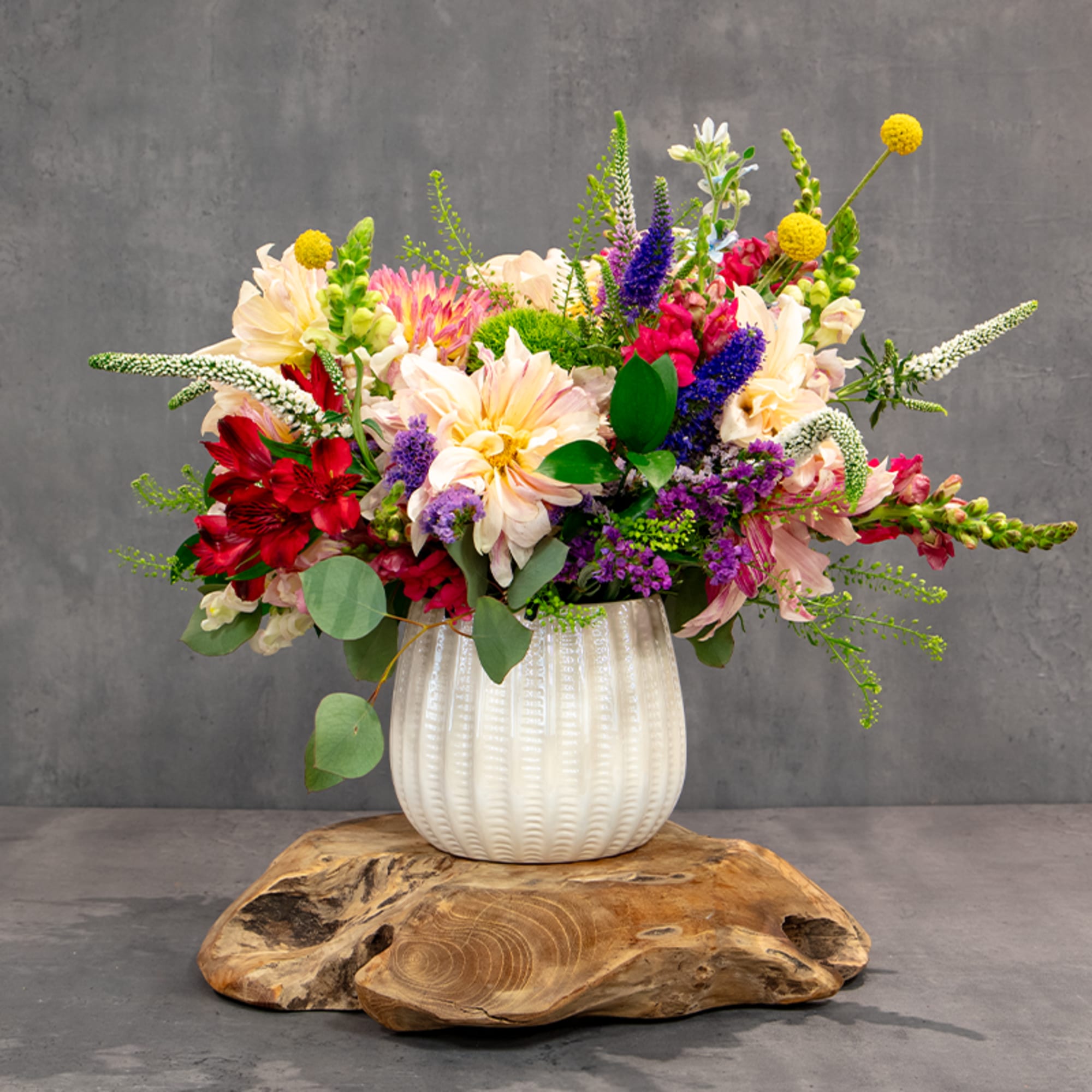 Colorful mixed flower arrangement in a white ribbed vase