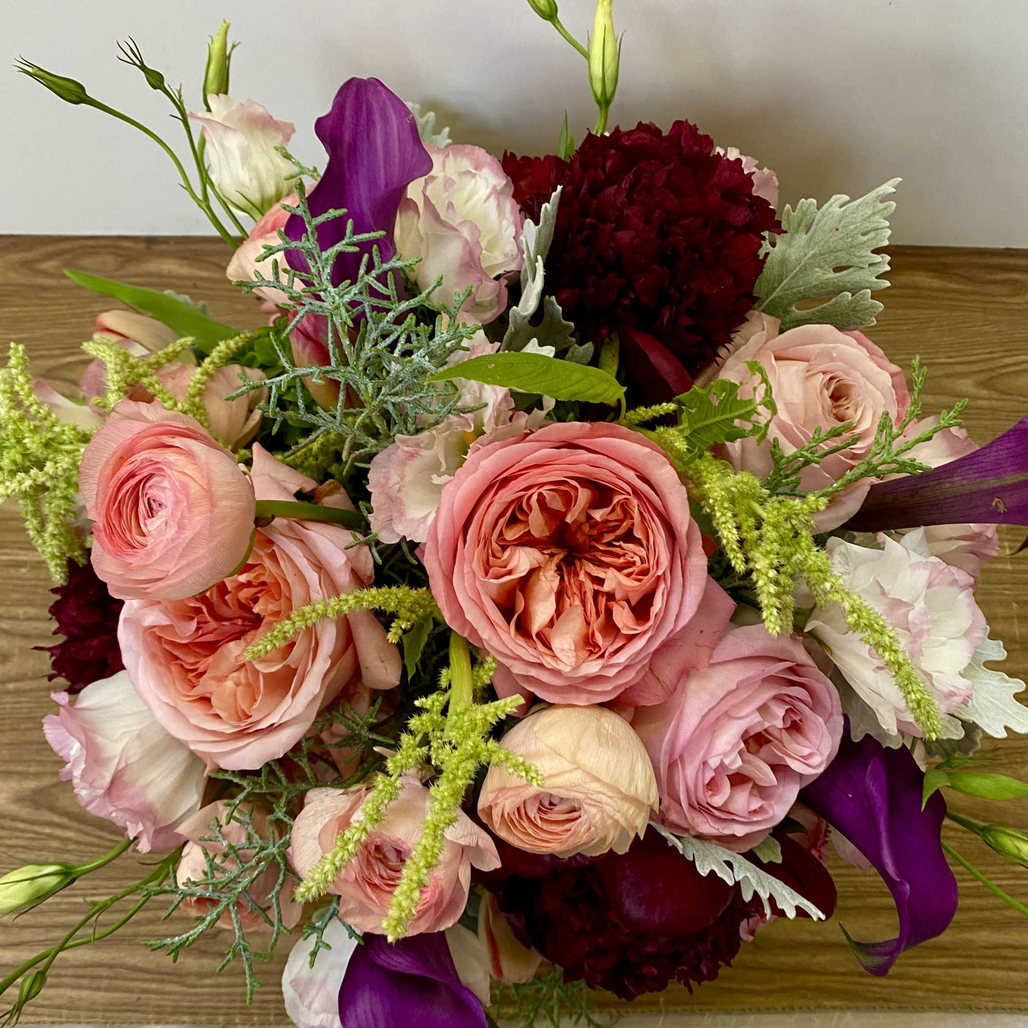 Bouquet of pink roses, purple calla lilies, and dark red carnations
