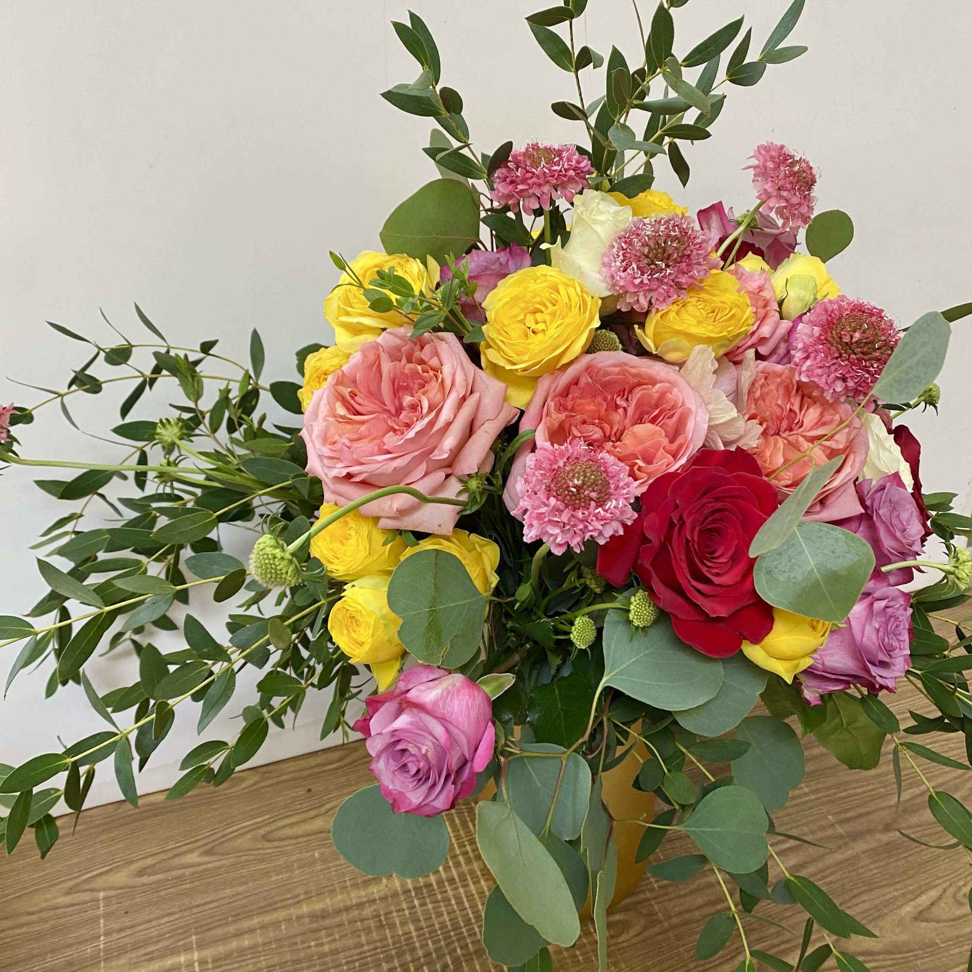Combination of different colors of flowers in a gold vase, photo 2 of 3