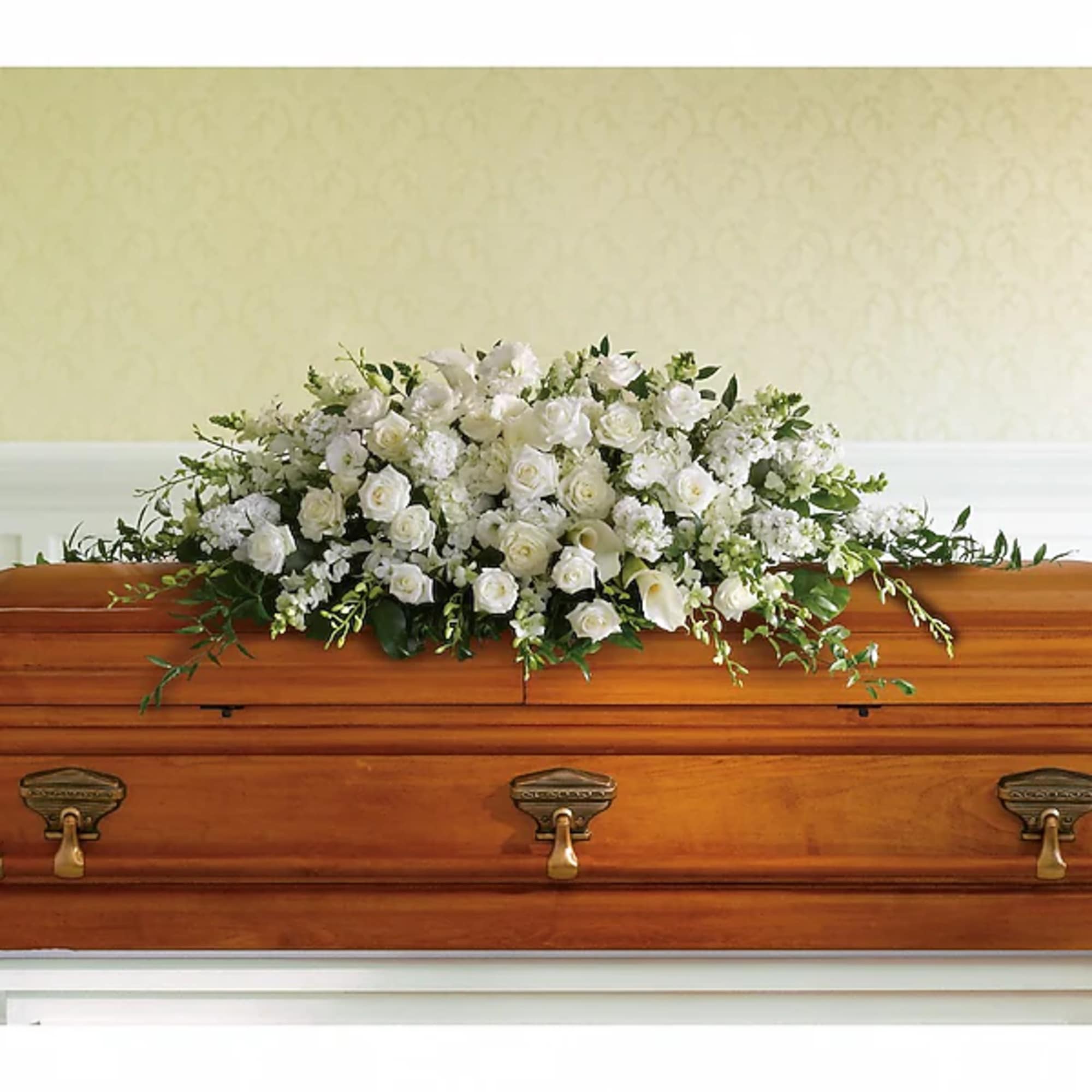 White floral spray arranged on a wooden casket