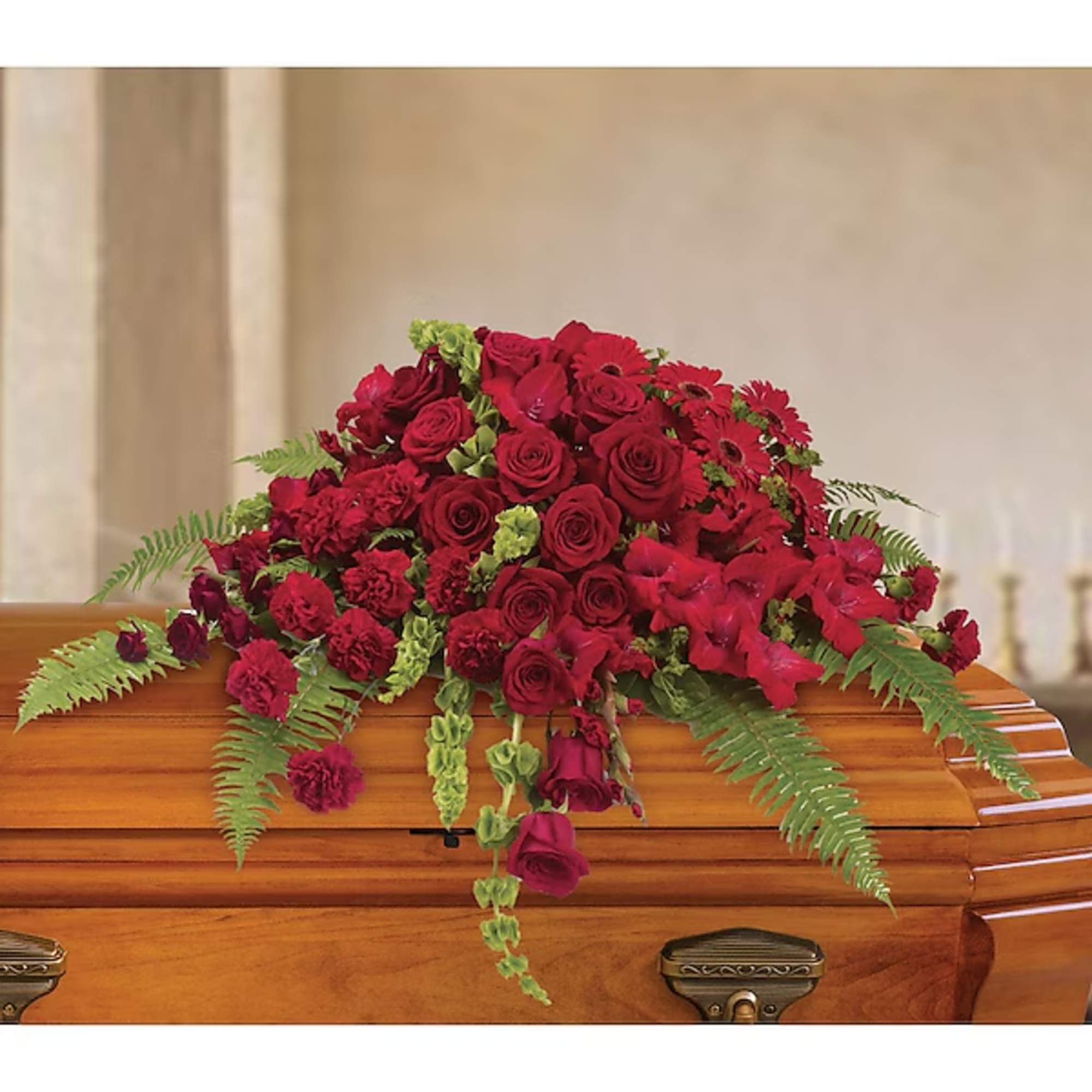 Red floral spray arranged on a wooden casket