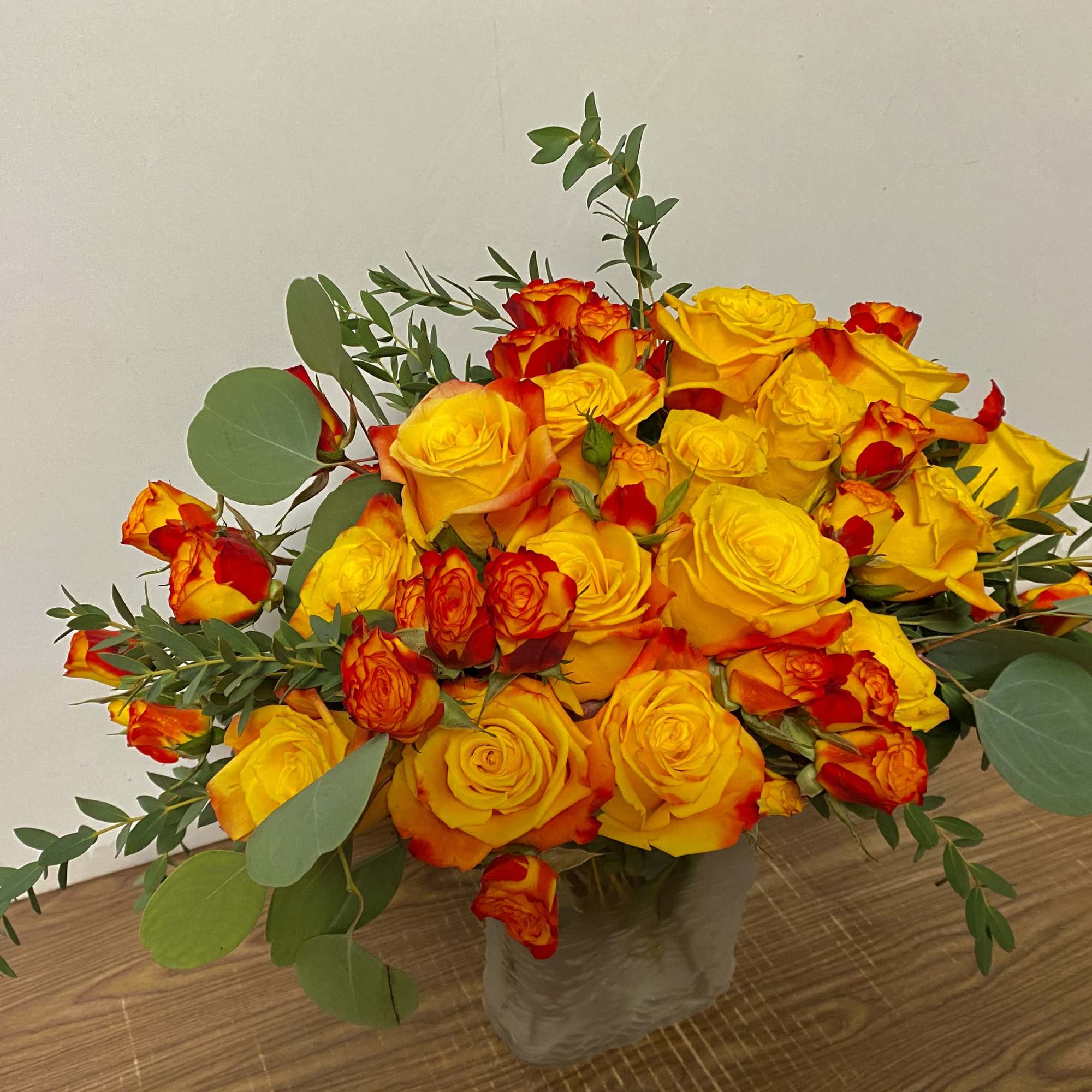 Bouquet of yellow and red roses in a clear vase