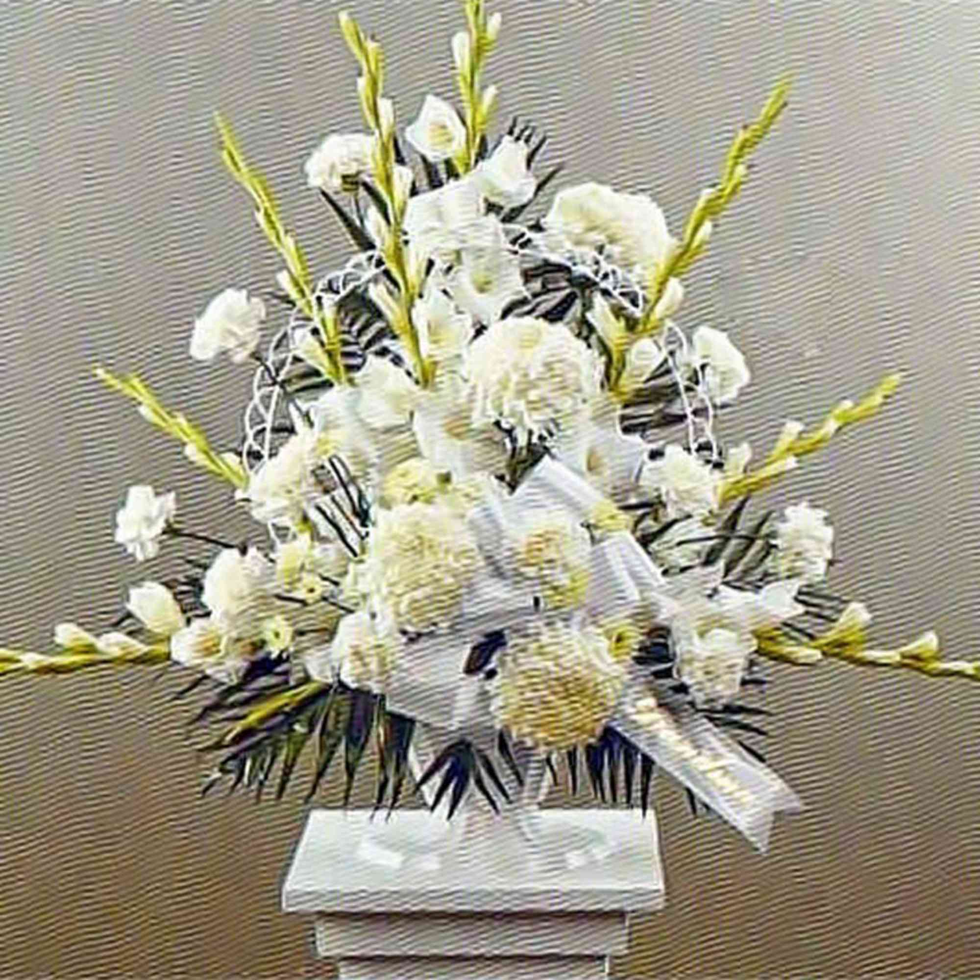Tall white sympathy arrangement with carnations and mums on a pedestal with a large white bow
