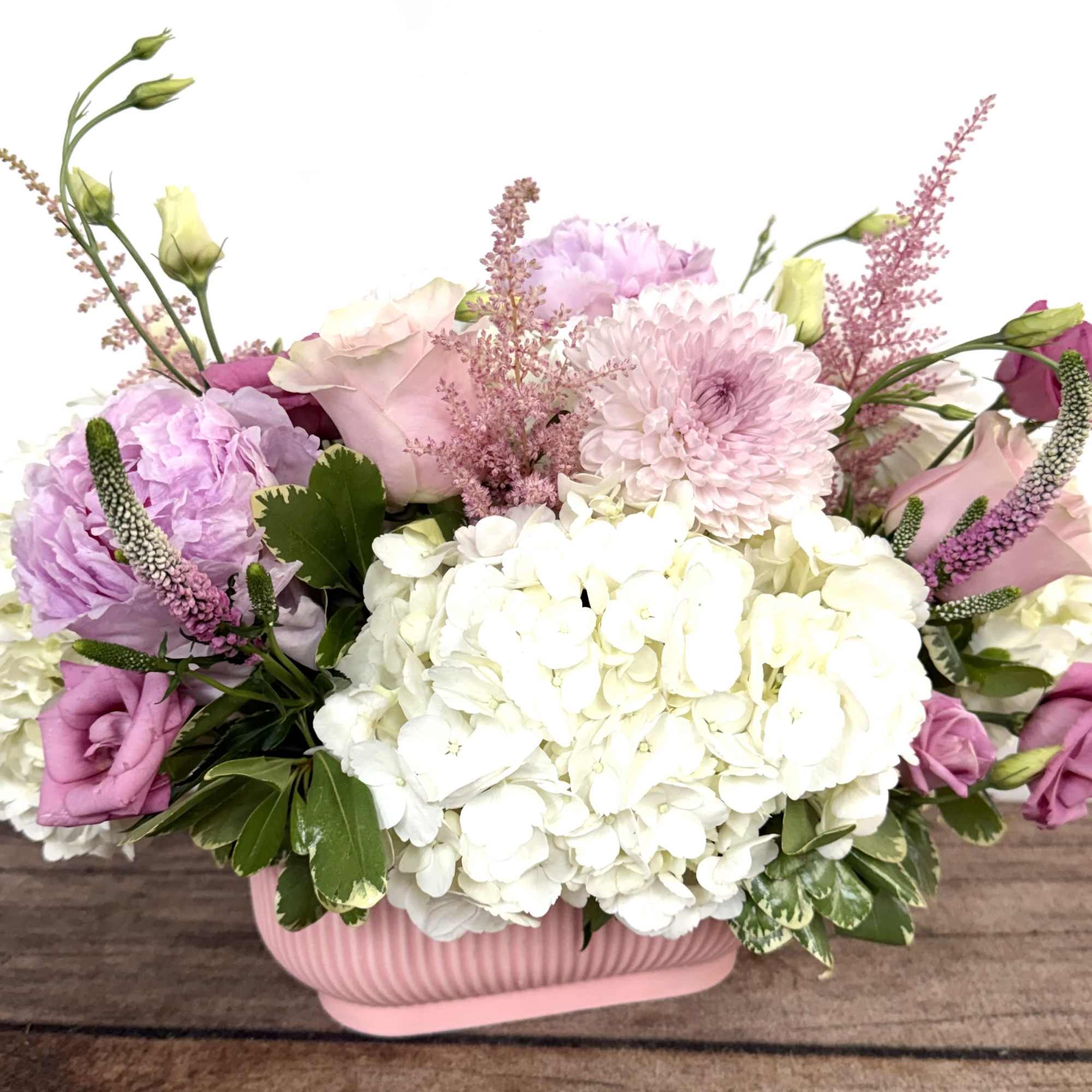 Blush pink blooms beautifully designed in a pink ceramic, textured container. Approx.