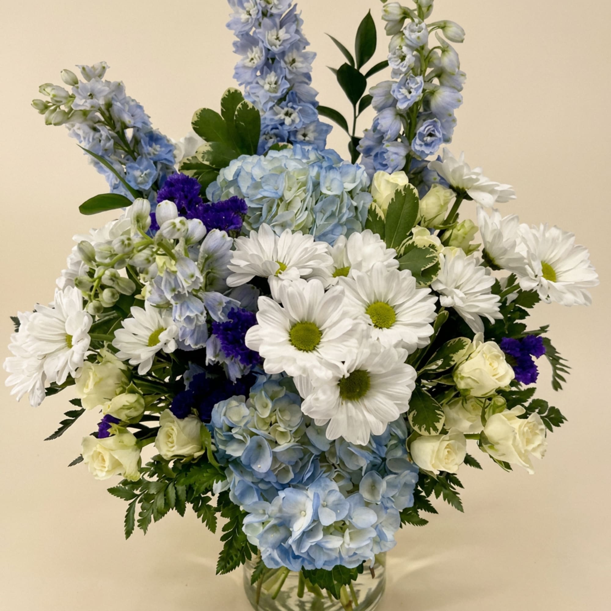 Blue and white floral arrangement in a clear glass vase